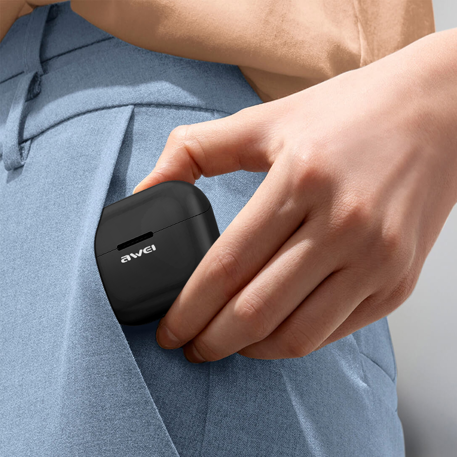 La mano di una persona che mette una custodia per auricolari wireless neri in una tasca blu.