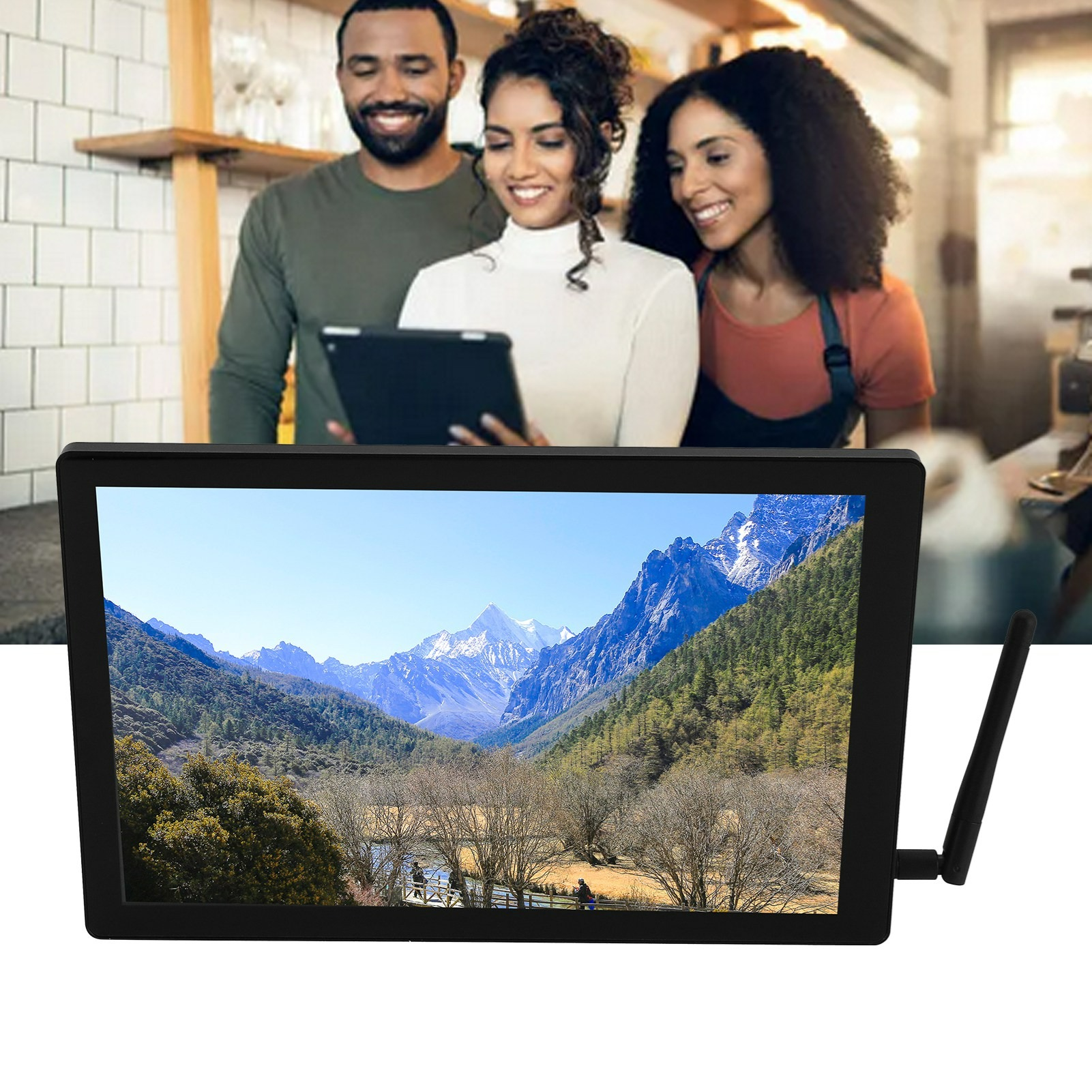 Monitor zeigt Berglandschaft, drei Personen schauen auf ein Tablet. Cafe-Einstellung.