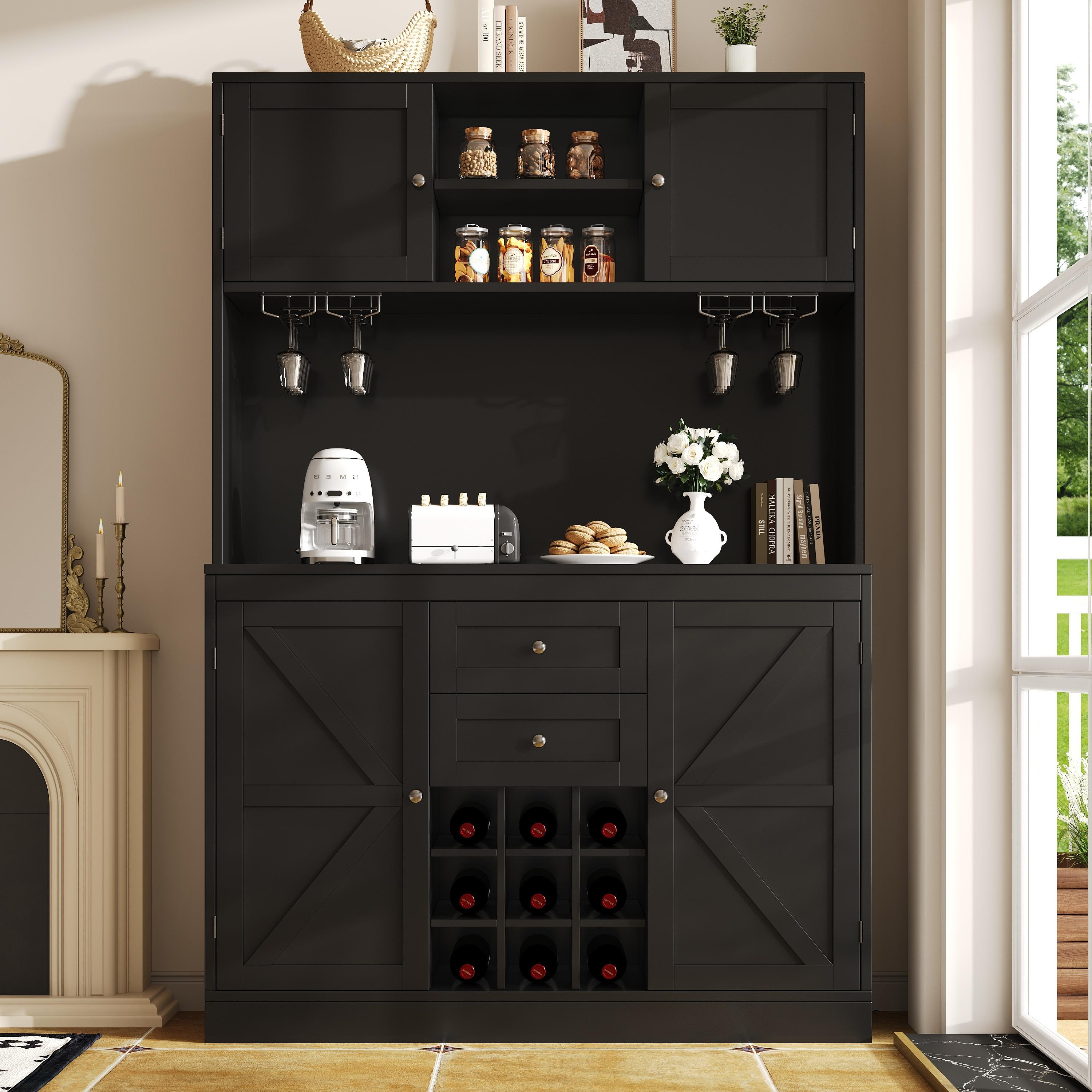 Schwarzer Schrank mit Aufsatz. Er hat Glashalterungen, einen Minikühlschrank und Gläser. Eine weiße Wand ist Hintergrund.