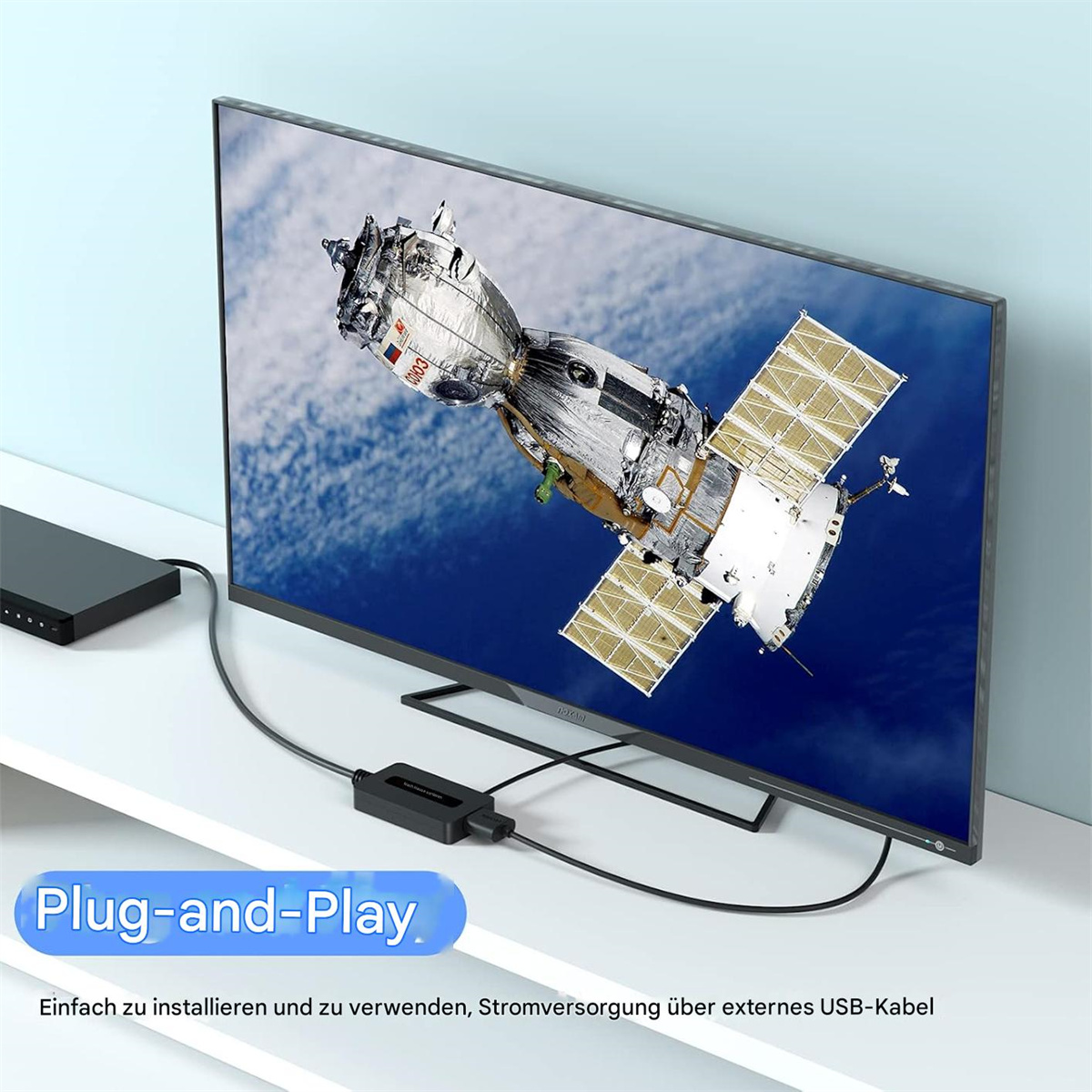 Ein Fernsehbildschirm mit einer Raumstation im Weltraum, verbunden mit einem schwarzen Plug-and-Play-Gerät.
