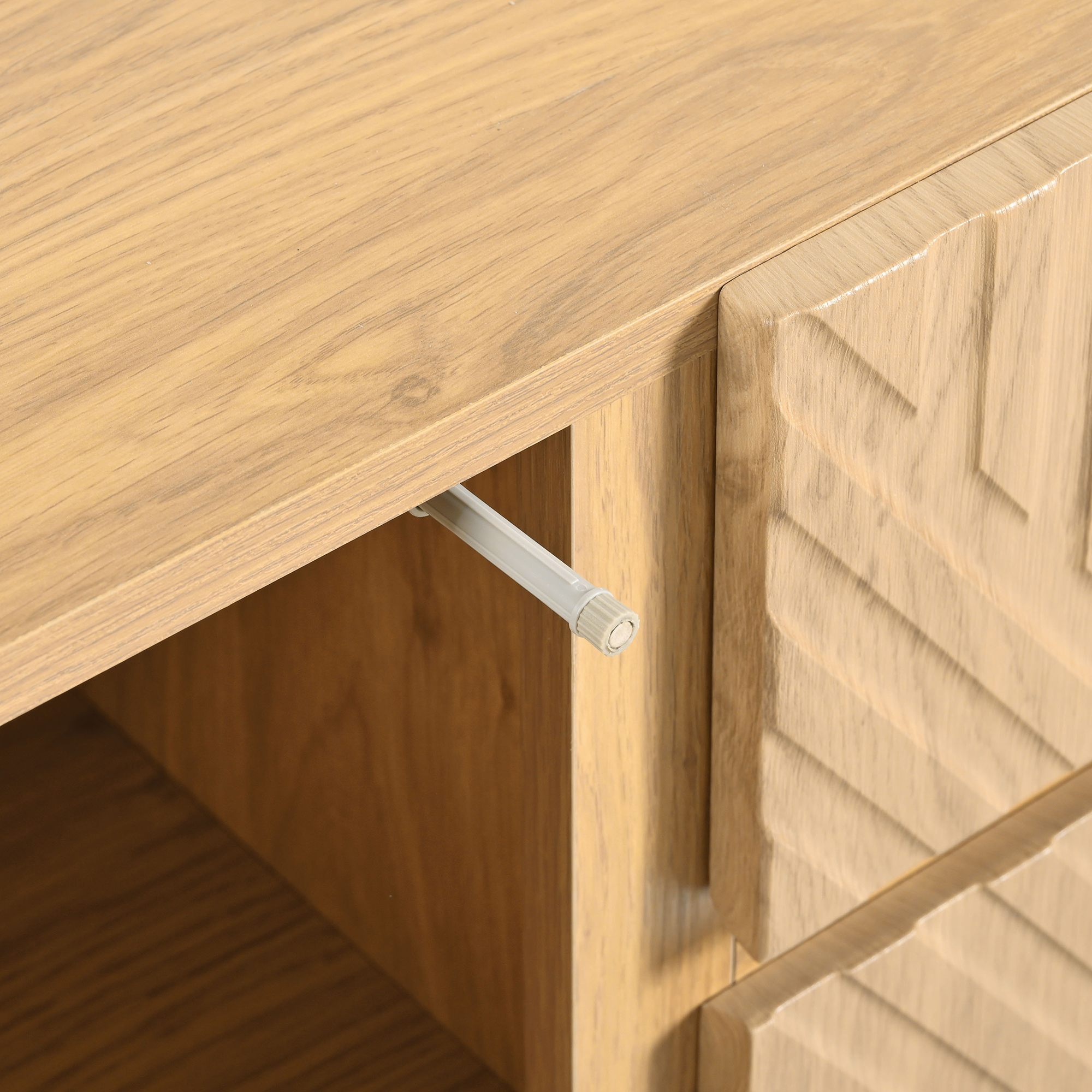 Holzschrankdetail mit Schublade, Push-to-Open-Mechanismus und strukturierter Oberfläche.