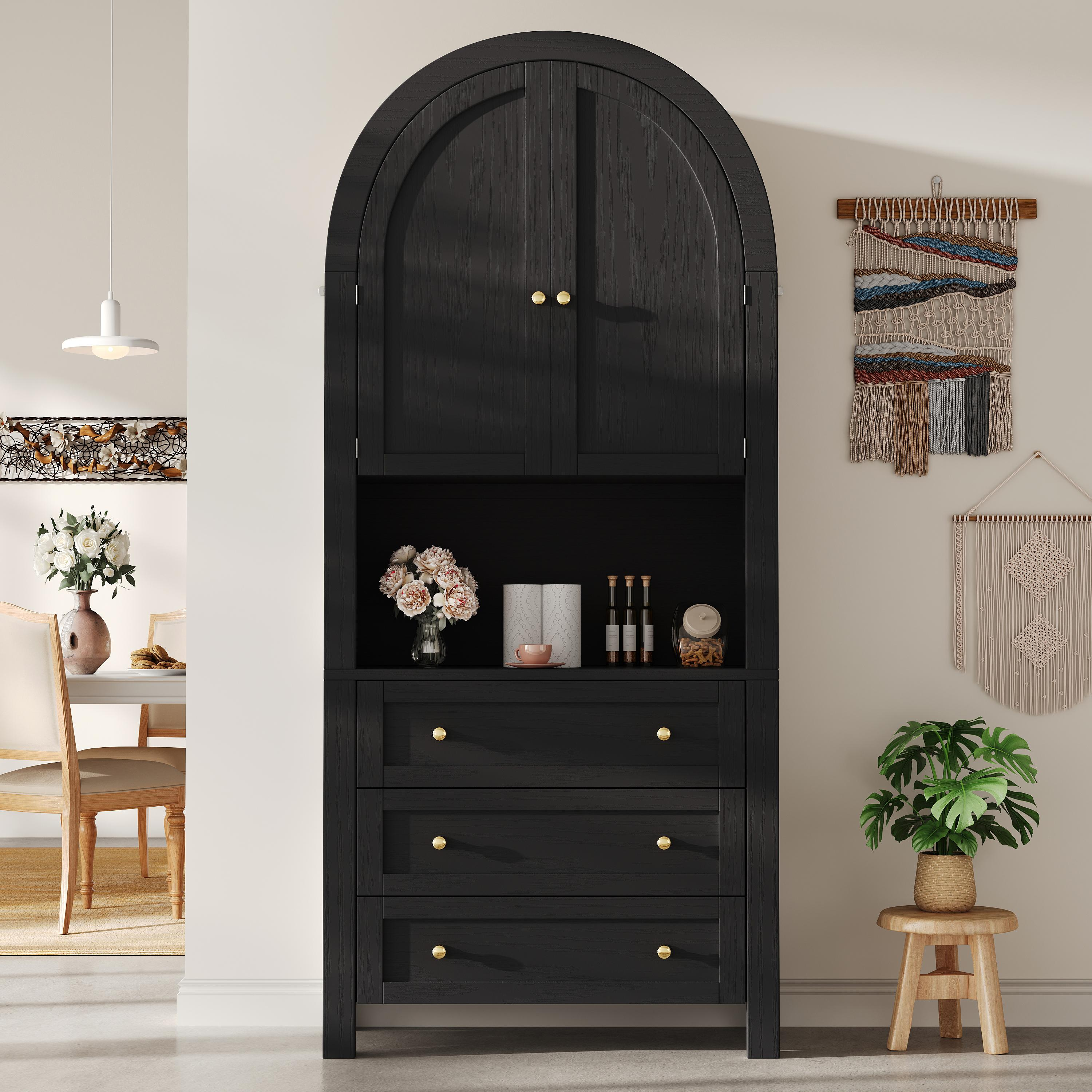 Ein schwarzer Schrank mit Schubladen und gewölbtem Oberteil, mit Kunst und Pflanzen dekoriert.