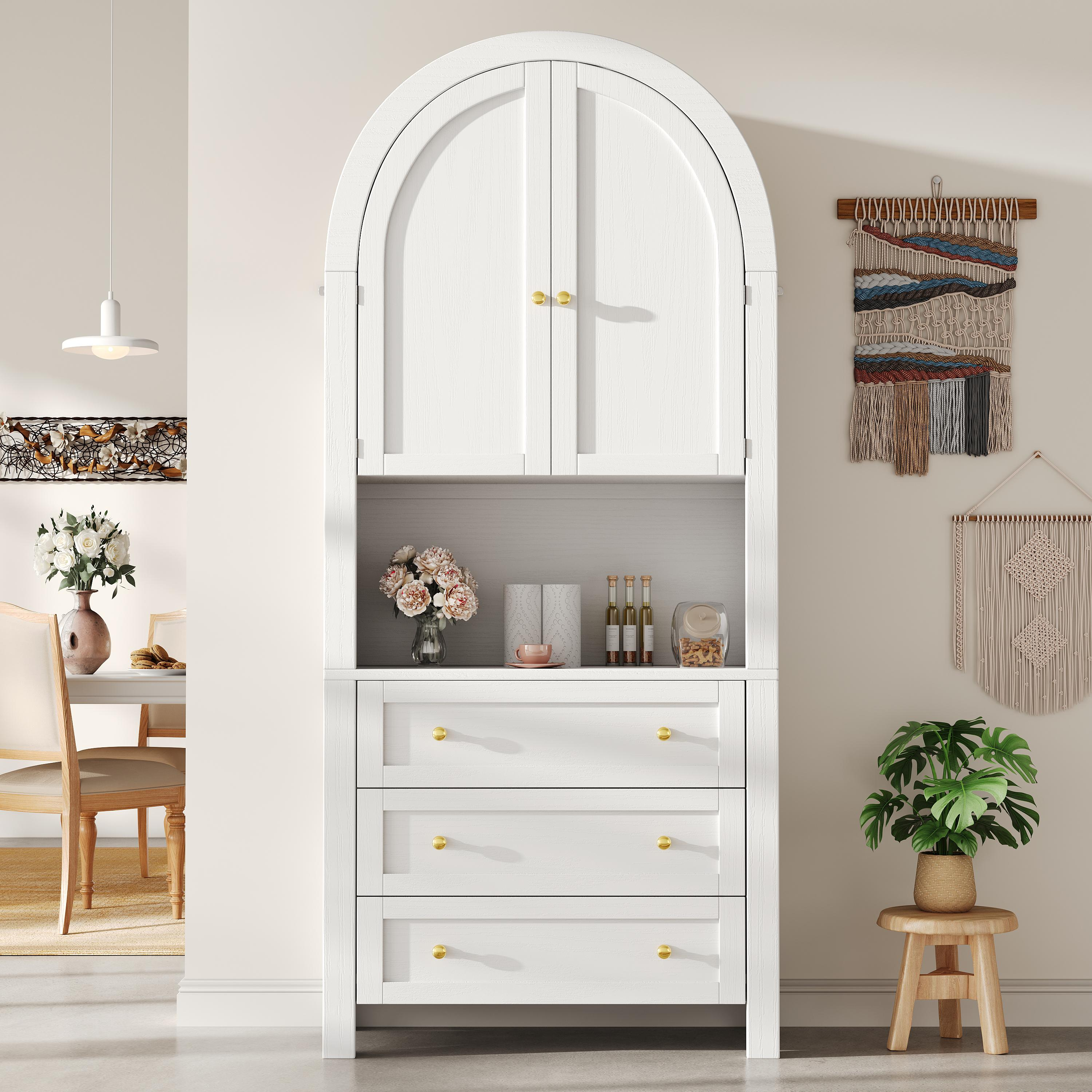 Ein weißer Schrank mit gewölbtem Oberteil, offenen Türen und Schubladen vor einer beigefarbenen Wand.