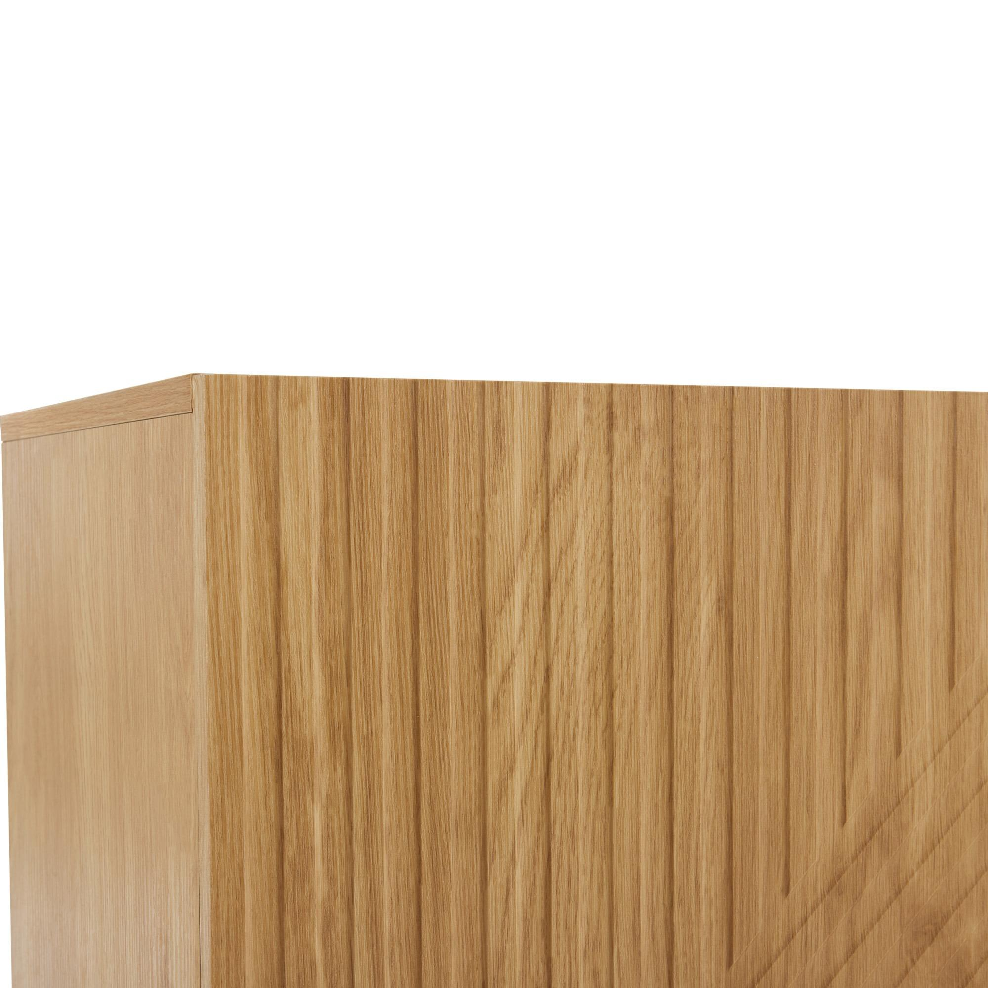 Ecke eines Holzschranks mit strukturierter Maserung. Das Holz ist hellbraun.