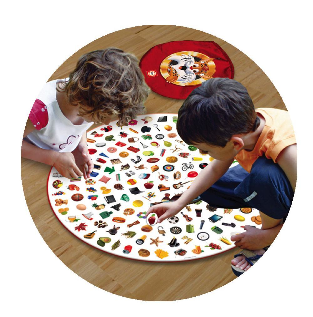 Dos niños jugando a un juego en una alfombra circular llena de varios objetos pequeños.