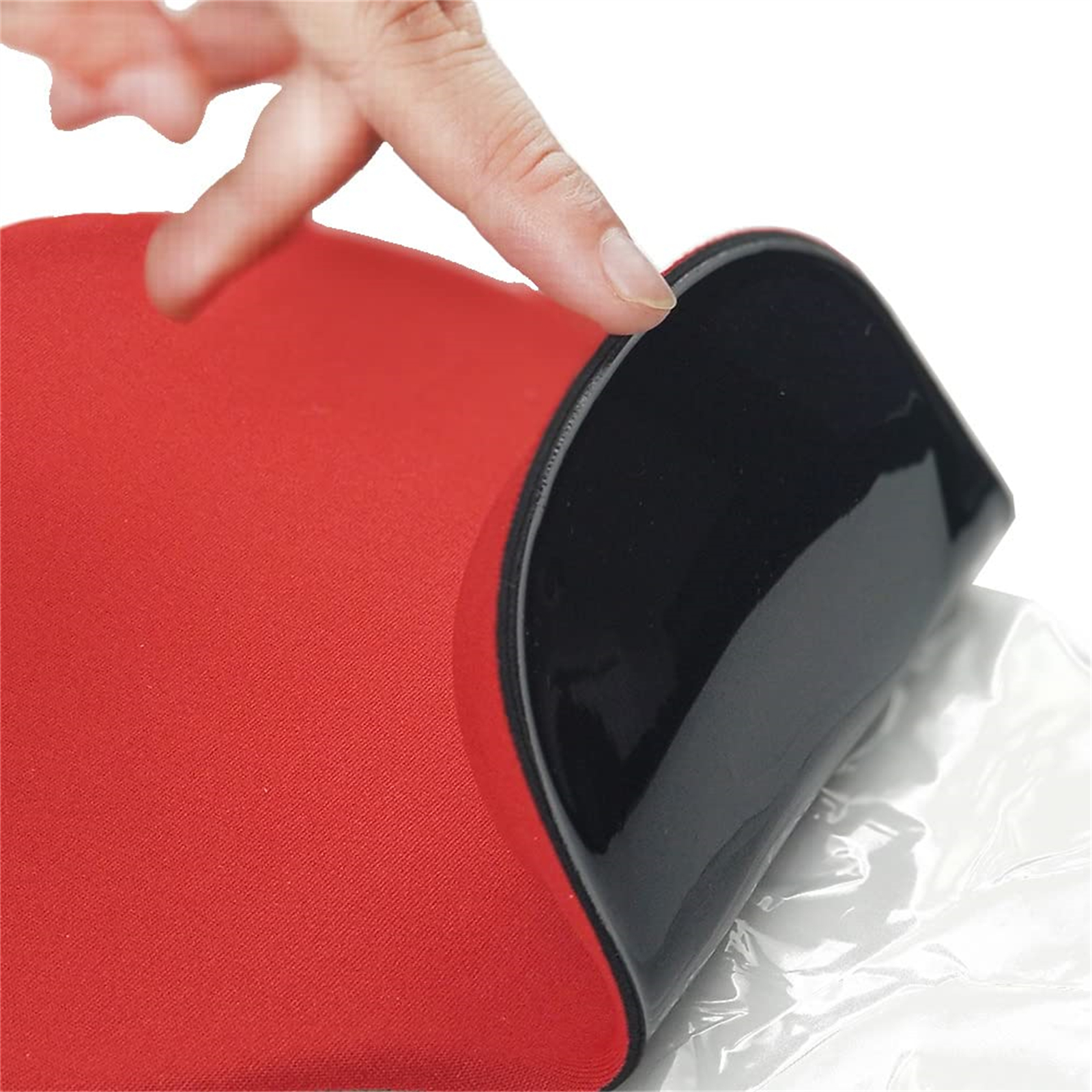 Hand, die ein rot-schwarzes Mauspad abzieht und die schwarze Schicht freilegt.
