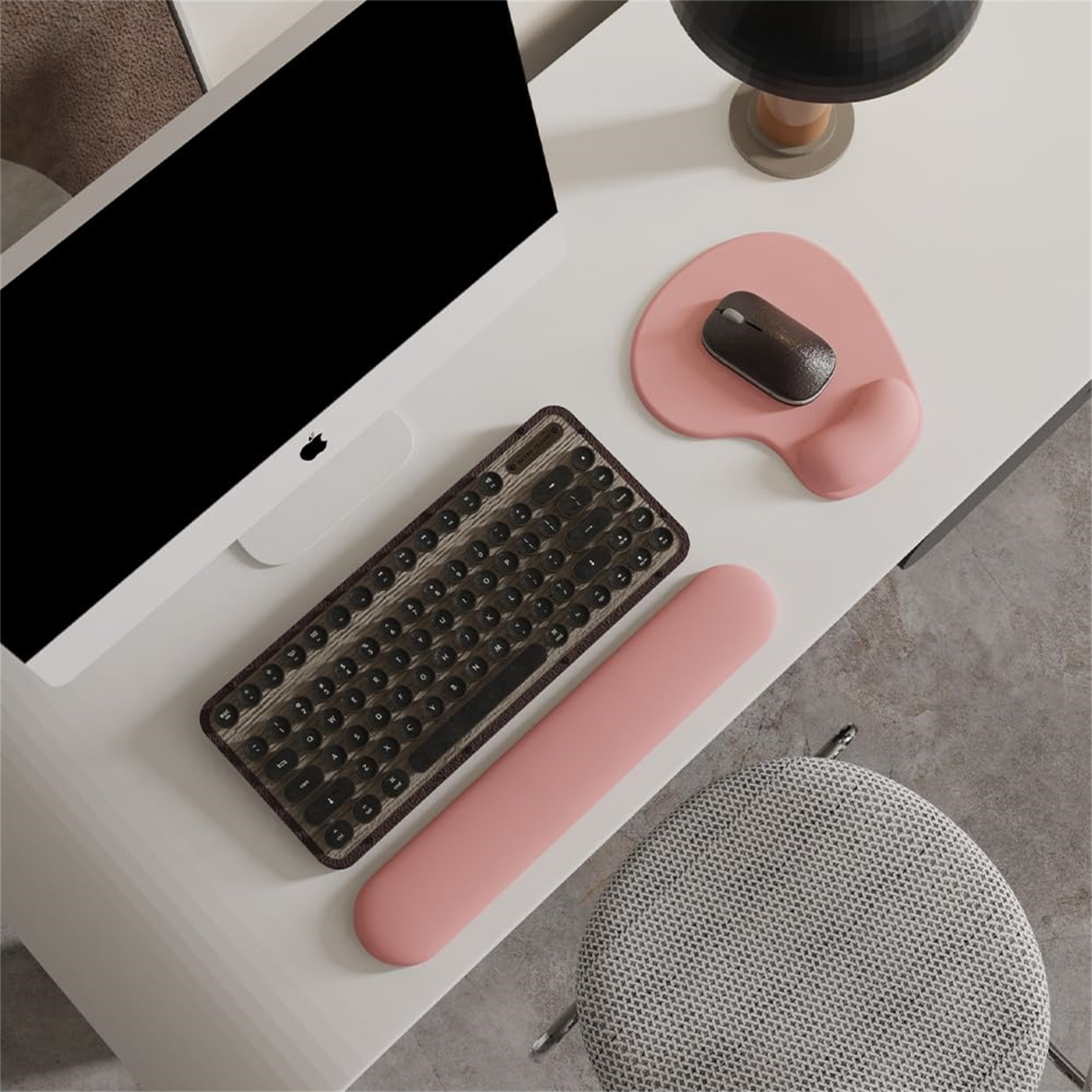 Ein Schreibtisch-Setup mit Tastatur, Maus und pinkfarbener Handgelenkauflage, weißer Hintergrund.