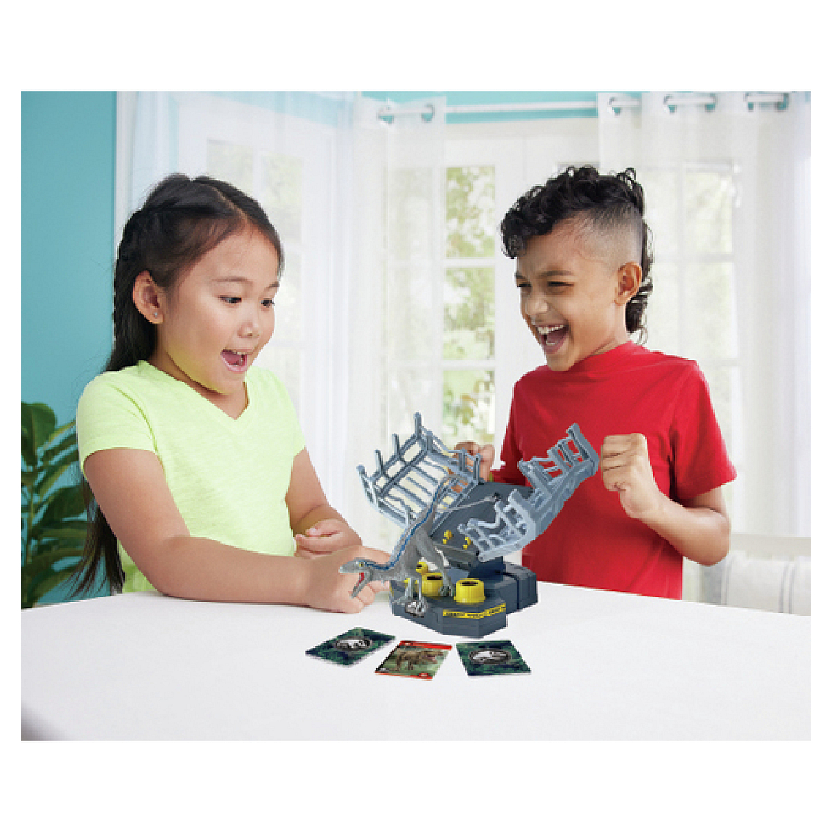 Zwei aufgeregte Kinder spielen mit einem Dinosaurierspiel. Karten liegen auf dem Tisch.