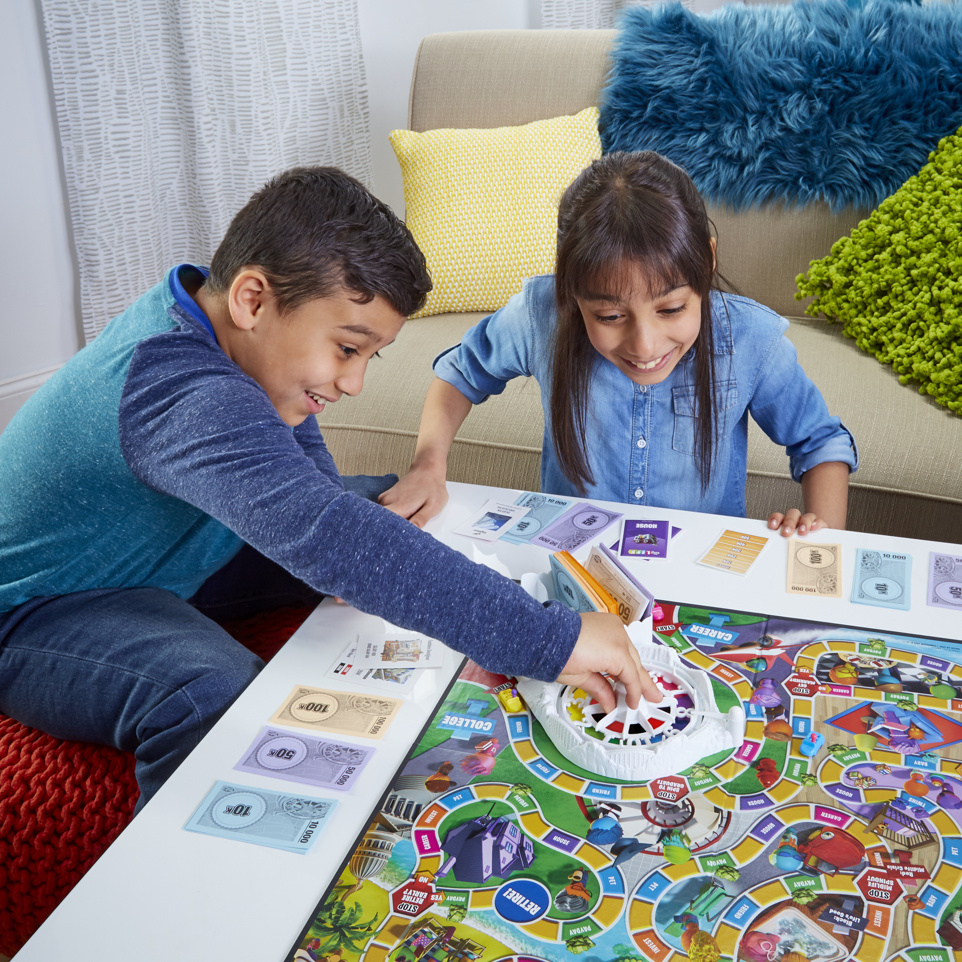Twee kinderen spelen een bordspel, gefocust op het bord met geld en tokens.