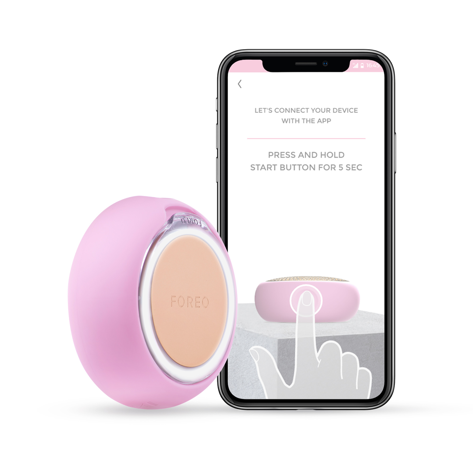 Un dispositivo Foreo Bear rosa junto a un teléfono que muestra instrucciones de la aplicación.