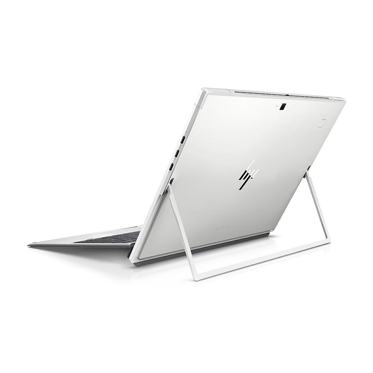Srebrny laptop z białą podstawką; ekran jest pochylony, pokazując tył urządzenia.