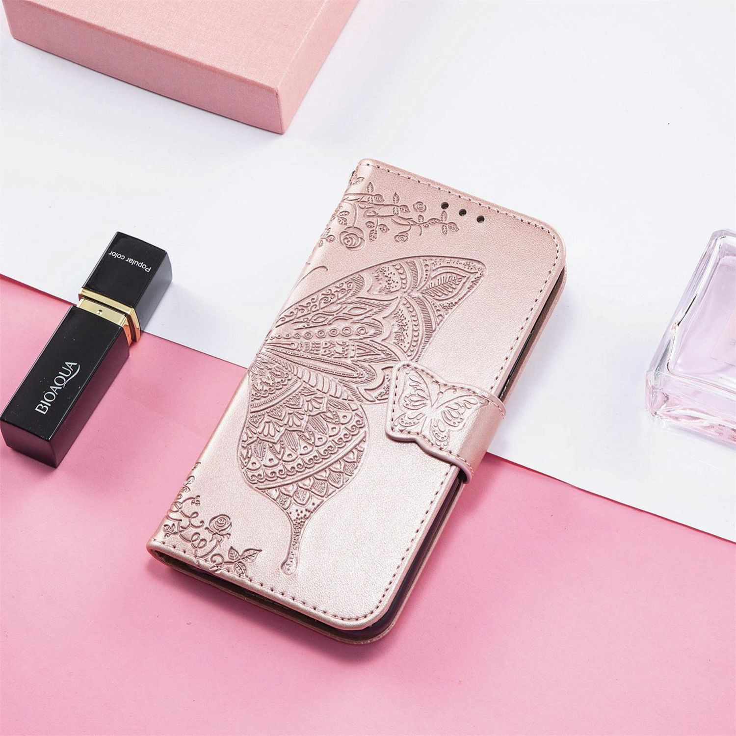 Rosa Handyhülle mit Schmetterlingsdesign. Inklusive Riemen und Lippenstift.