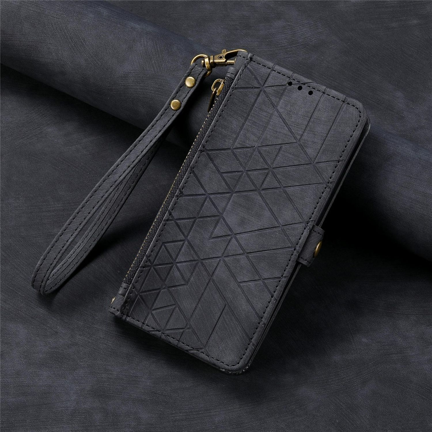 Eine schwarze Geldbörsenhülle mit geometrischem Muster, Reißverschluss und Handschlaufe, auf dunkler Oberfläche.