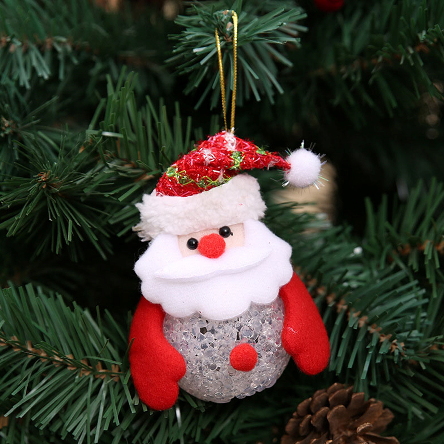 Addobbo natalizio: testa di Babbo Natale con cappello rosso e guanti rossi. Aghi di pino verdi sullo sfondo.