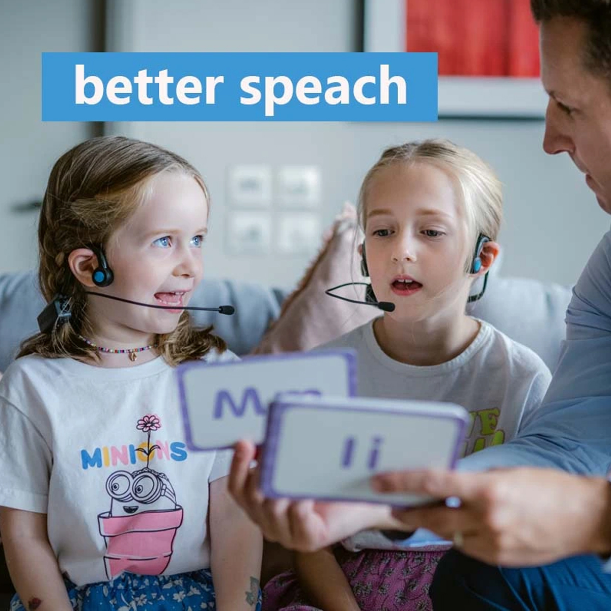 Zwei Mädchen mit Headsets und ein Mann mit Karten.