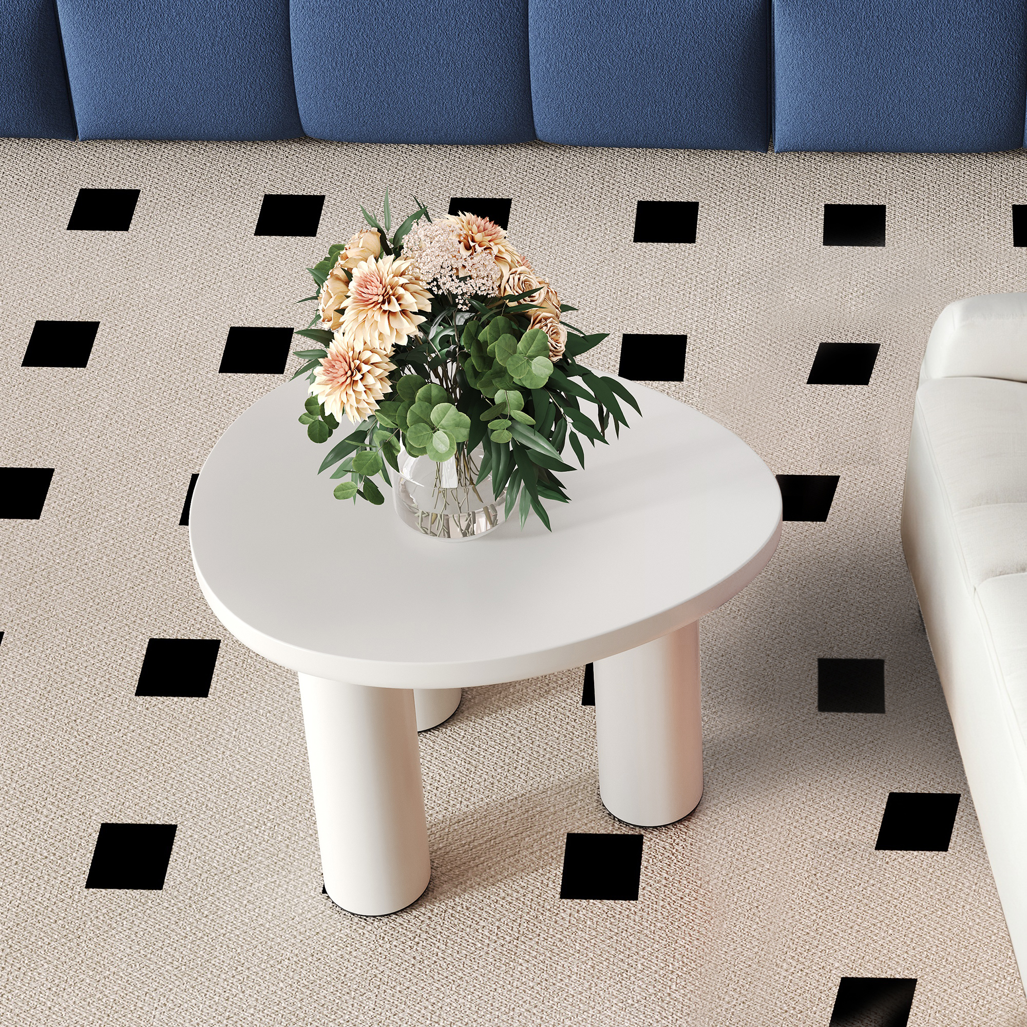 Draufsicht auf einen weißen runden Couchtisch mit Blumen, platziert zwischen einem weißen und einem blauen Sofa.