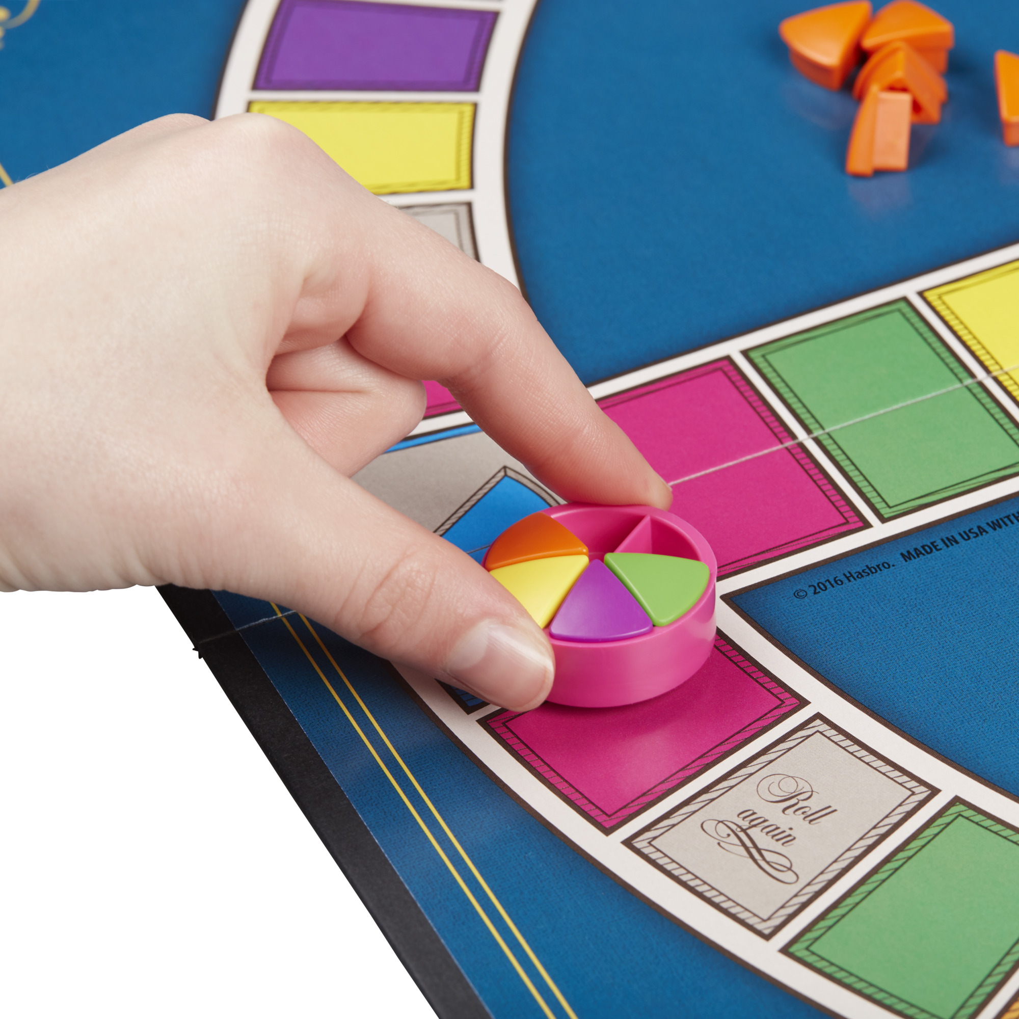 Een hand plaatst een roze spelstuk op een Life-bord. Andere stukken zijn zichtbaar.