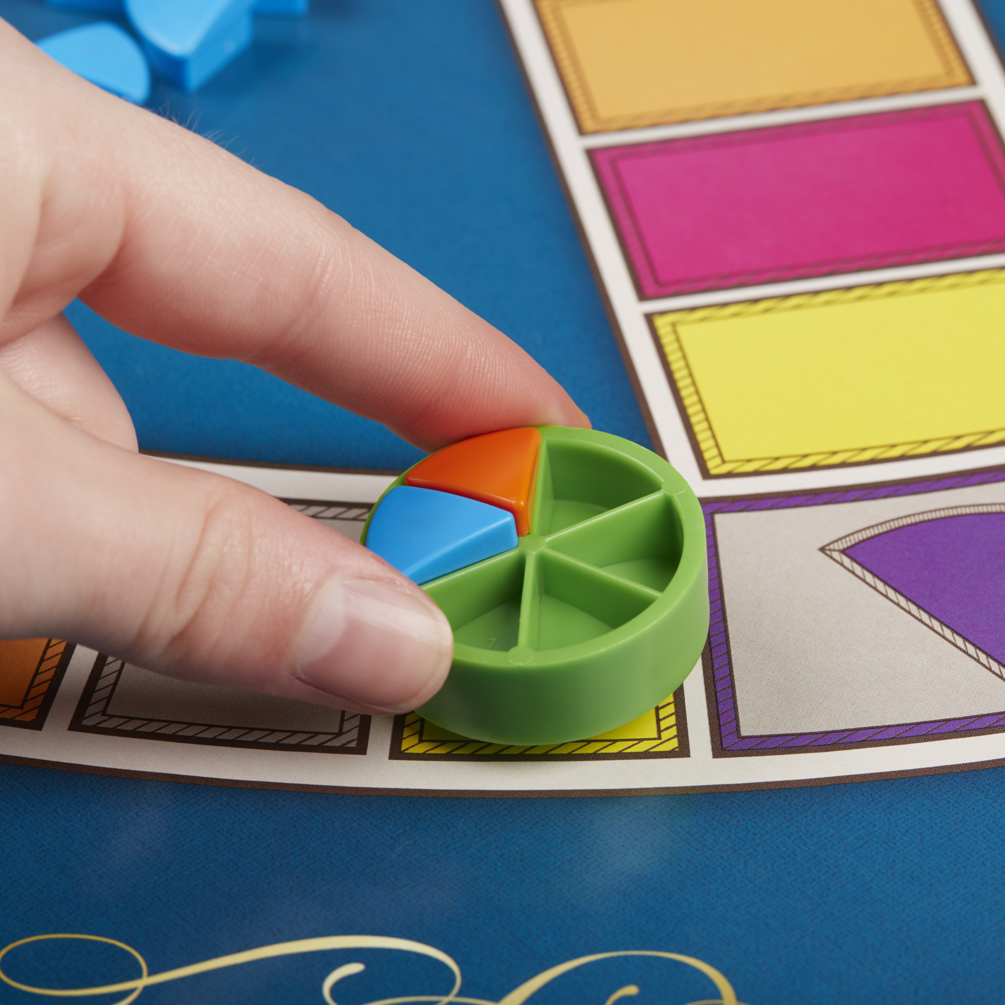 Hand die een taartpunt op een spelbord vasthoudt. Het bord heeft gekleurde vakken.