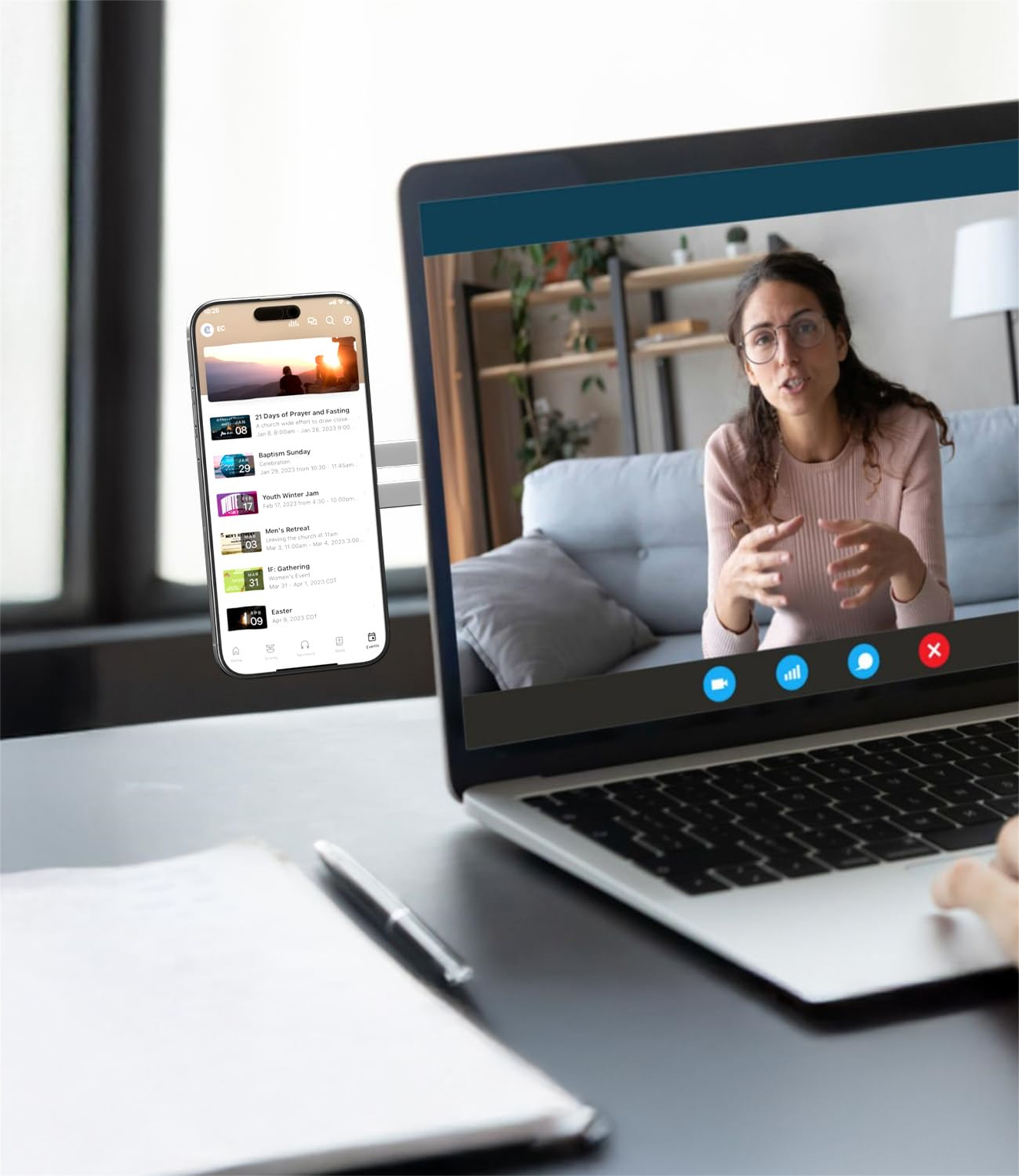 Ein Laptop zeigt einen Videoanruf mit einer Frau. Ein Telefon zeigt eine Kalender-App daneben.