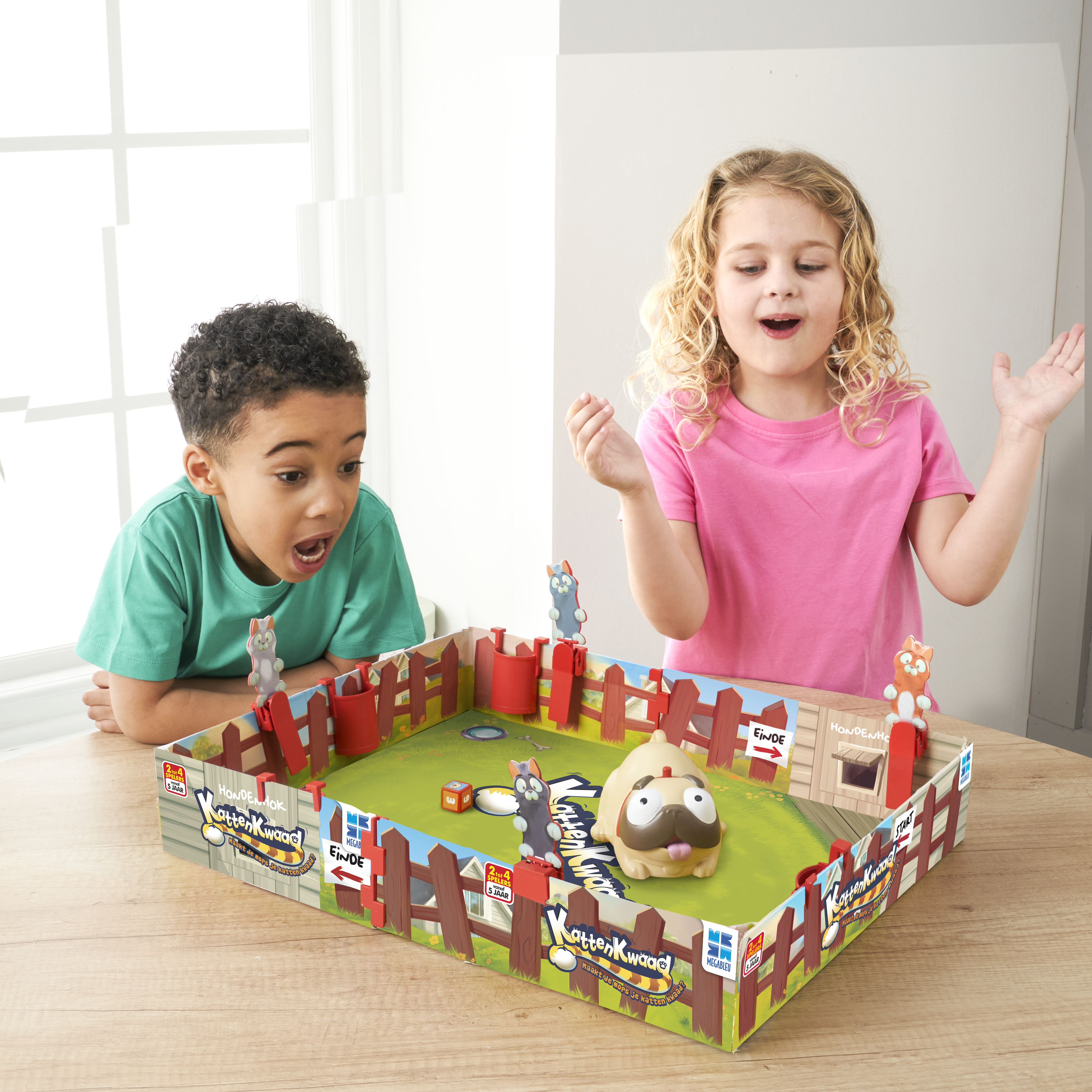 Twee kinderen spelen een bordspel. Ze kijken vol verbazing en opwinding naar het spel.