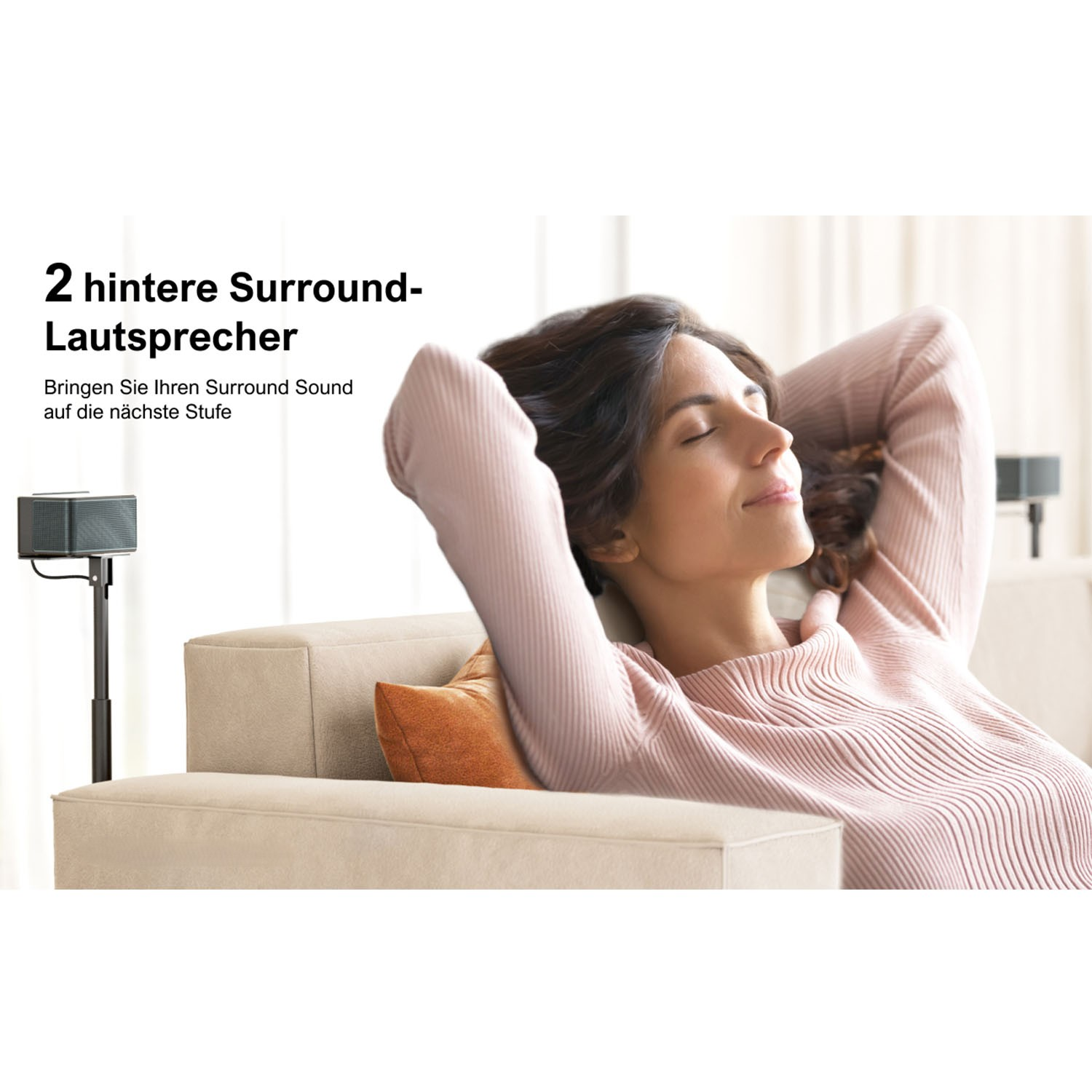 Frau entspannt sich auf einem Sofa mit Surround-Lautsprechern. Die Frau lächelt.
