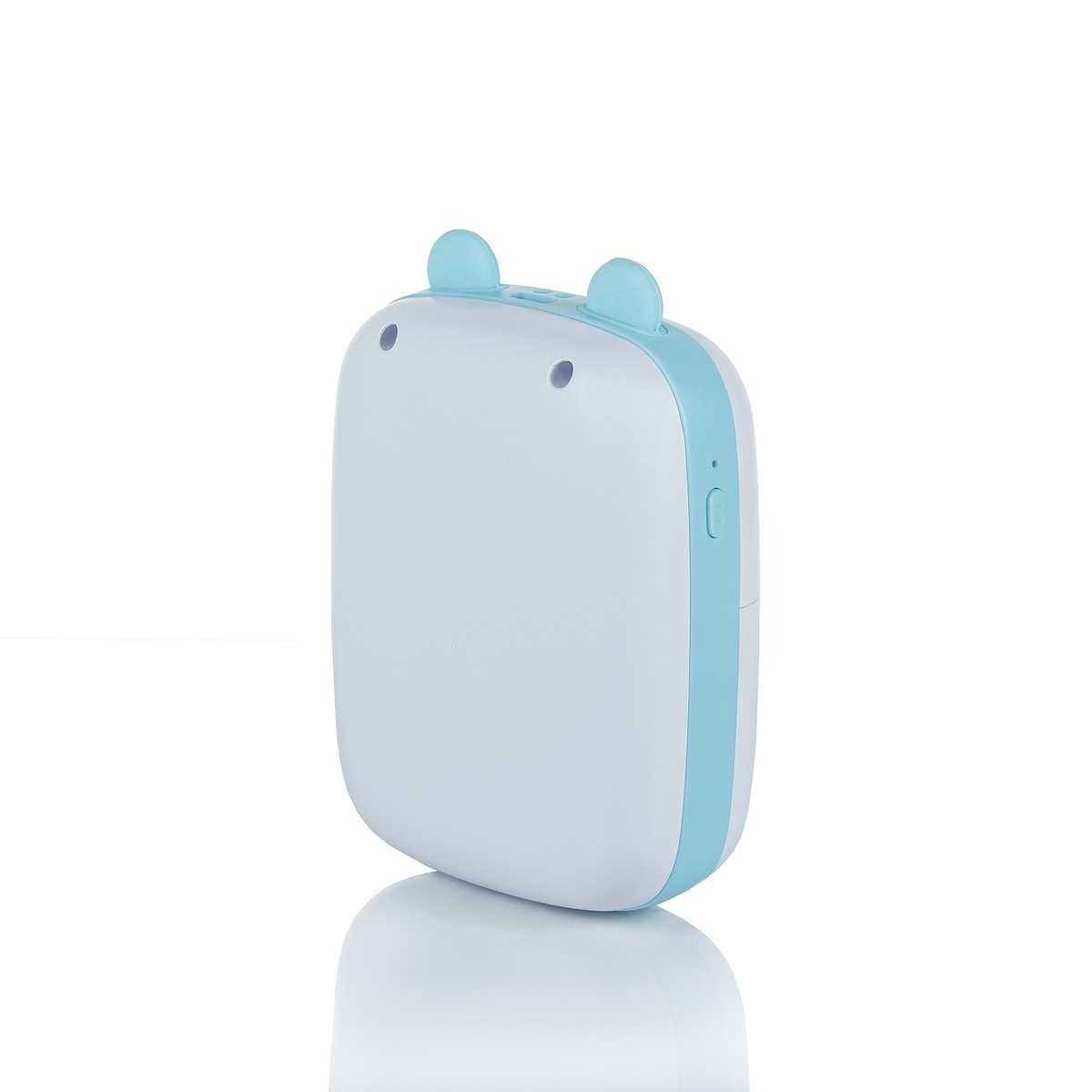 Małe, biało-niebieskie urządzenie z dwoma uszami. Leży na białej powierzchni.