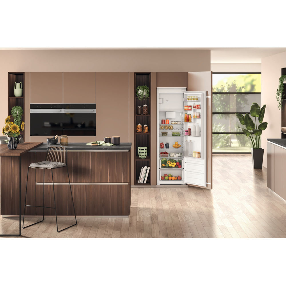 Cucina con frigorifero aperto. Mobili marroni, pavimento in legno e decorazioni.
