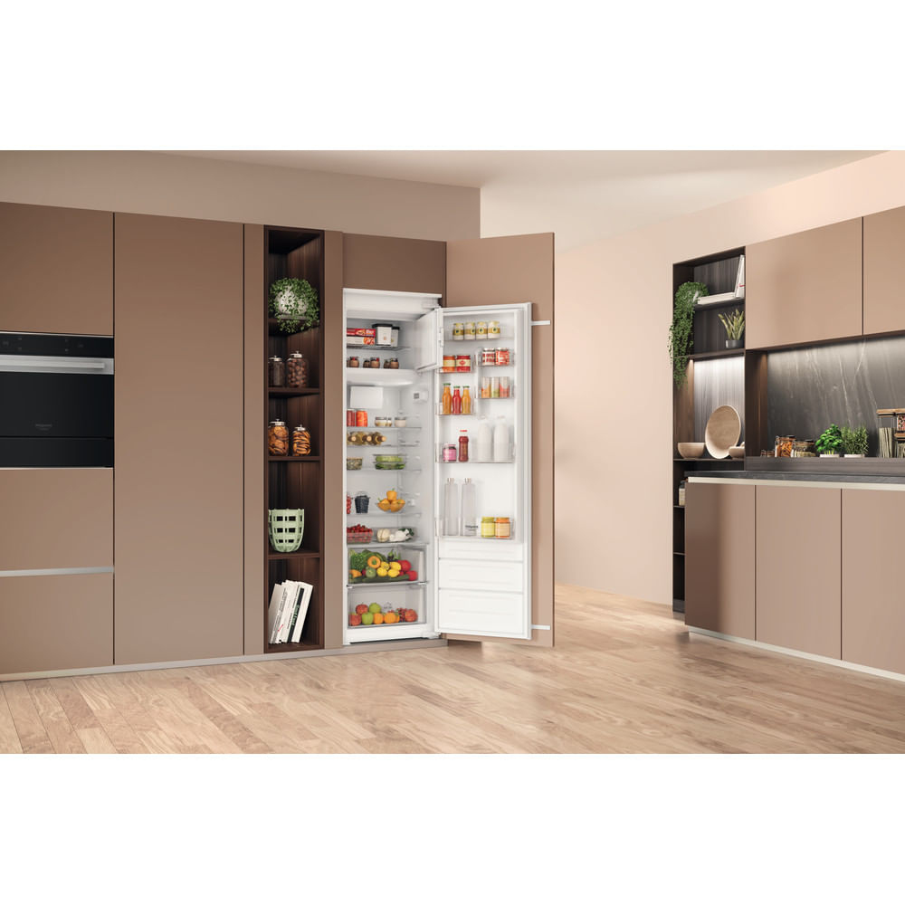 Cucina moderna con frigorifero aperto. Interno con cibi, bevande e frutta. Pavimento in legno.