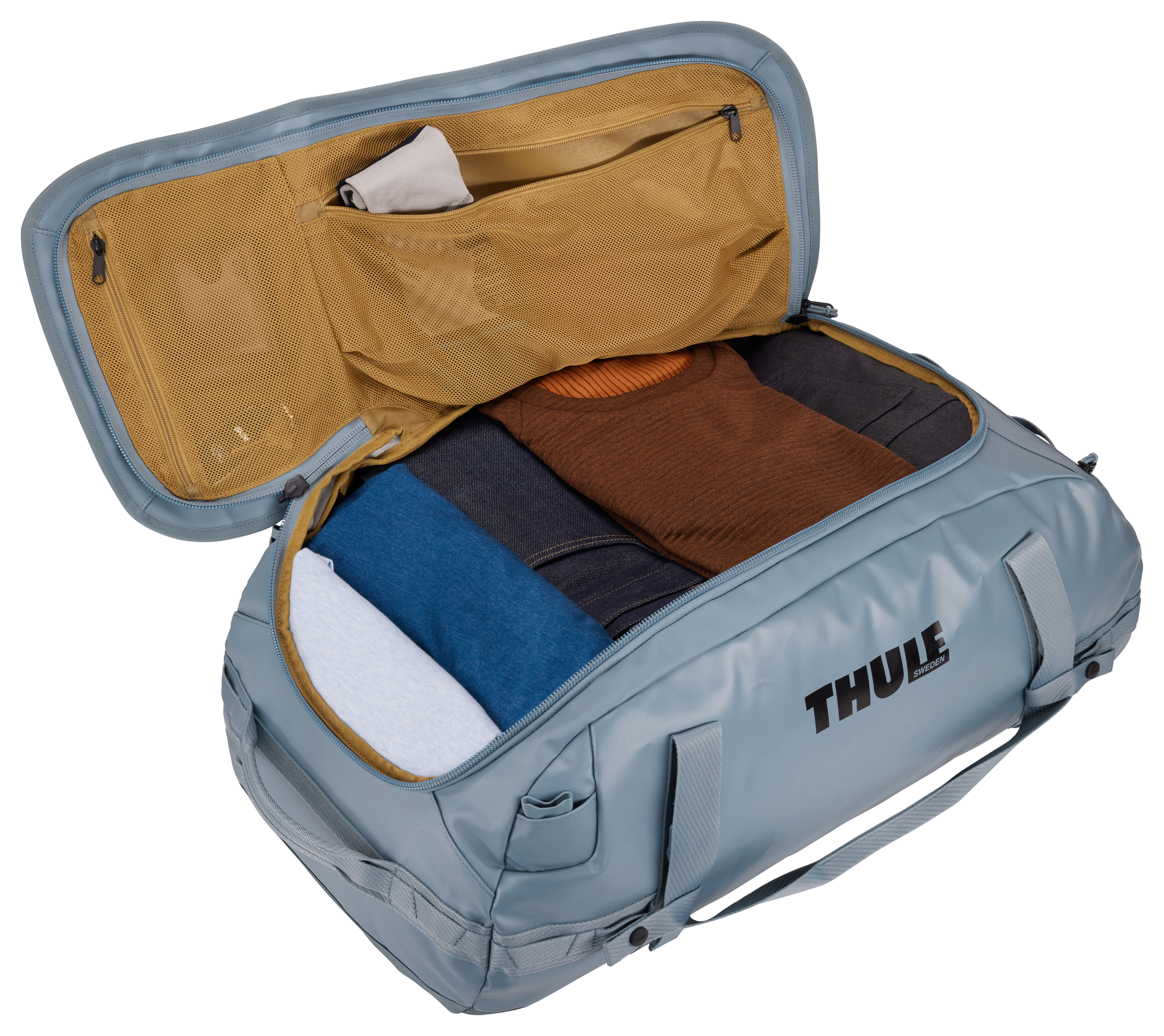 Blaue Reisetasche offen, mit Kleidung und einer Tasche. Weißer Hintergrund.