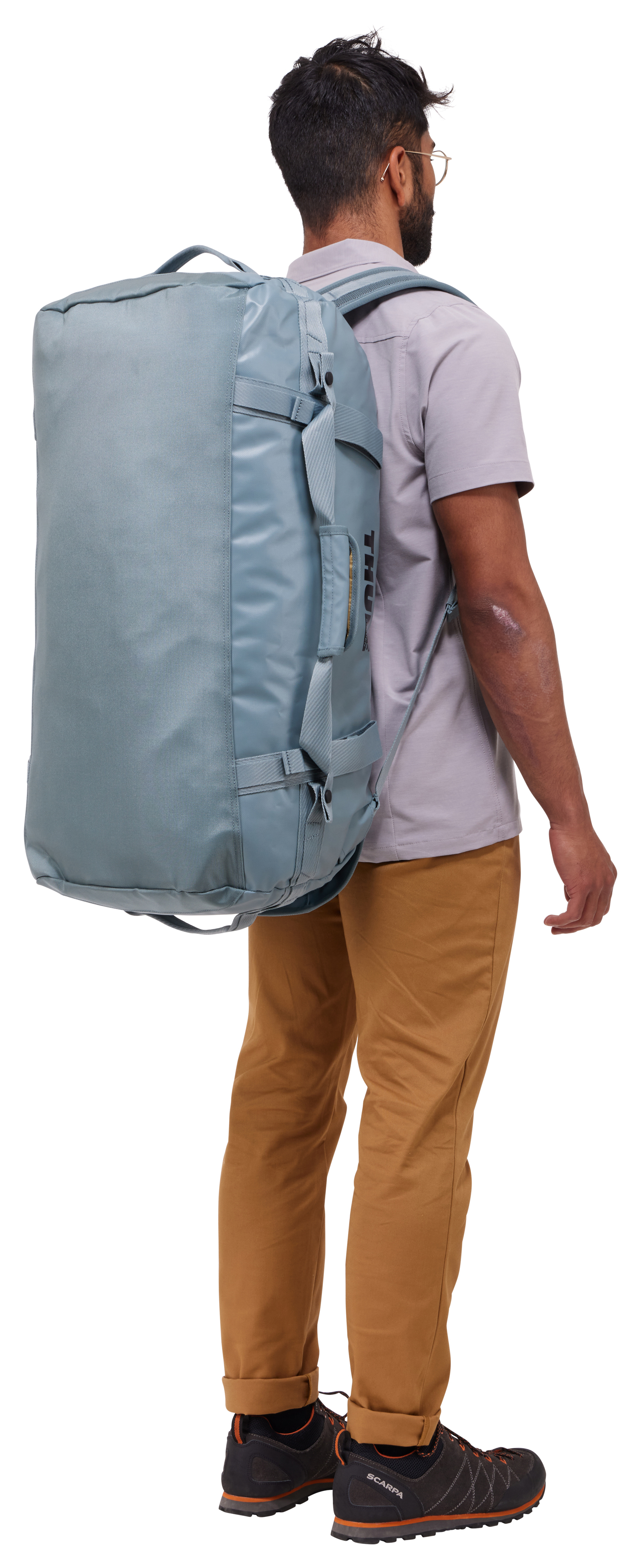 Mann mit Rucksack, abgewandt. Beige Hose, graues Hemd, schwarze Schuhe. Weißer Hintergrund.