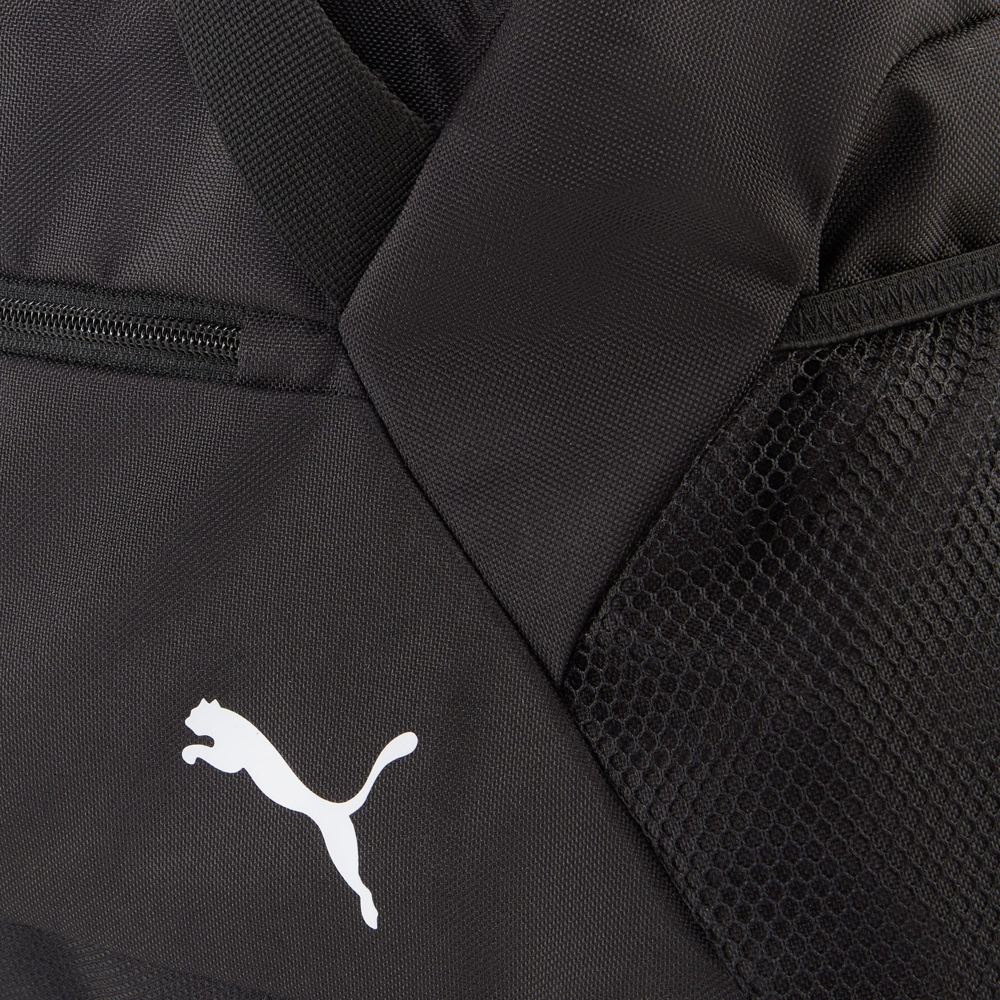 Zbliżenie czarnej torby z białym logo Puma. Widoczna jest również kieszeń z siatki.