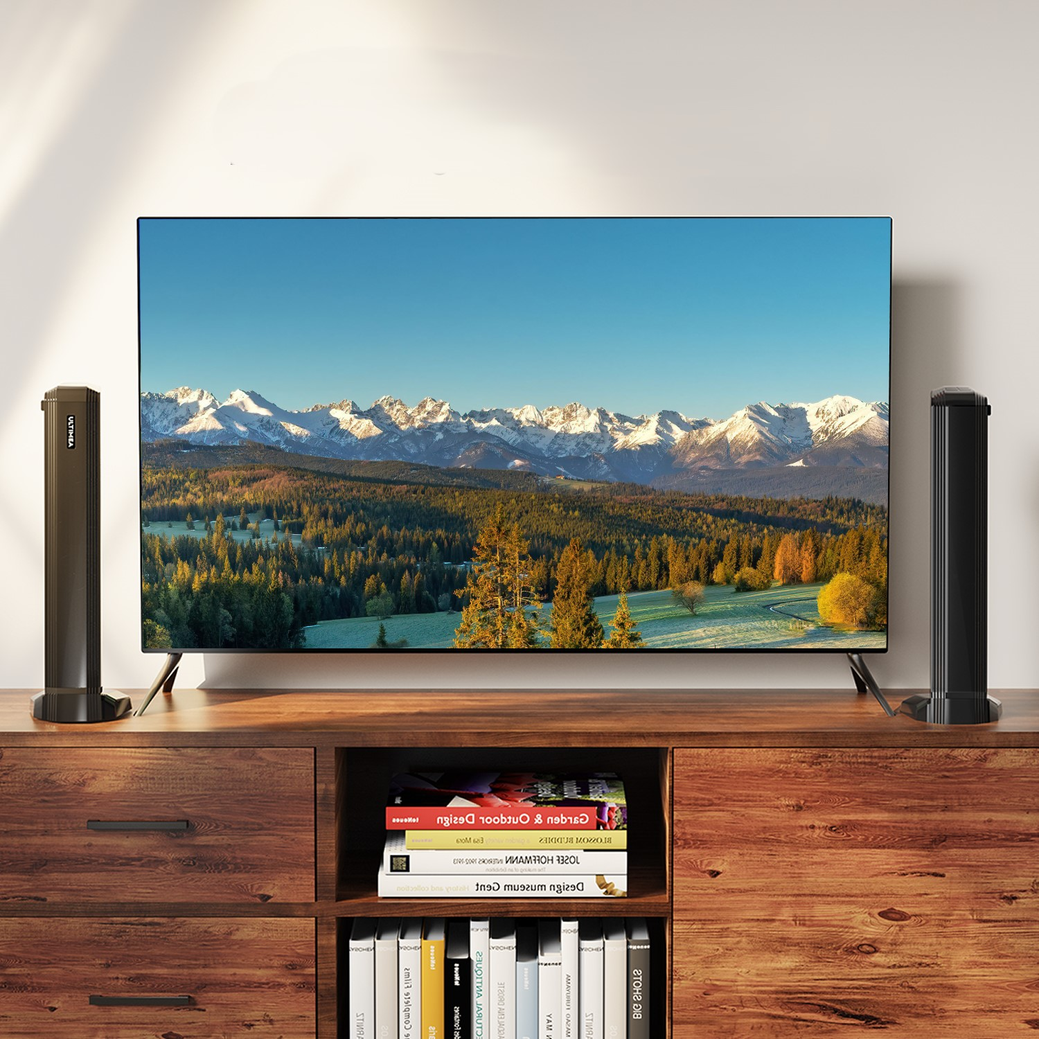 Ekran telewizora z górskim krajobrazem. Zamontowany na drewnianej szafce.