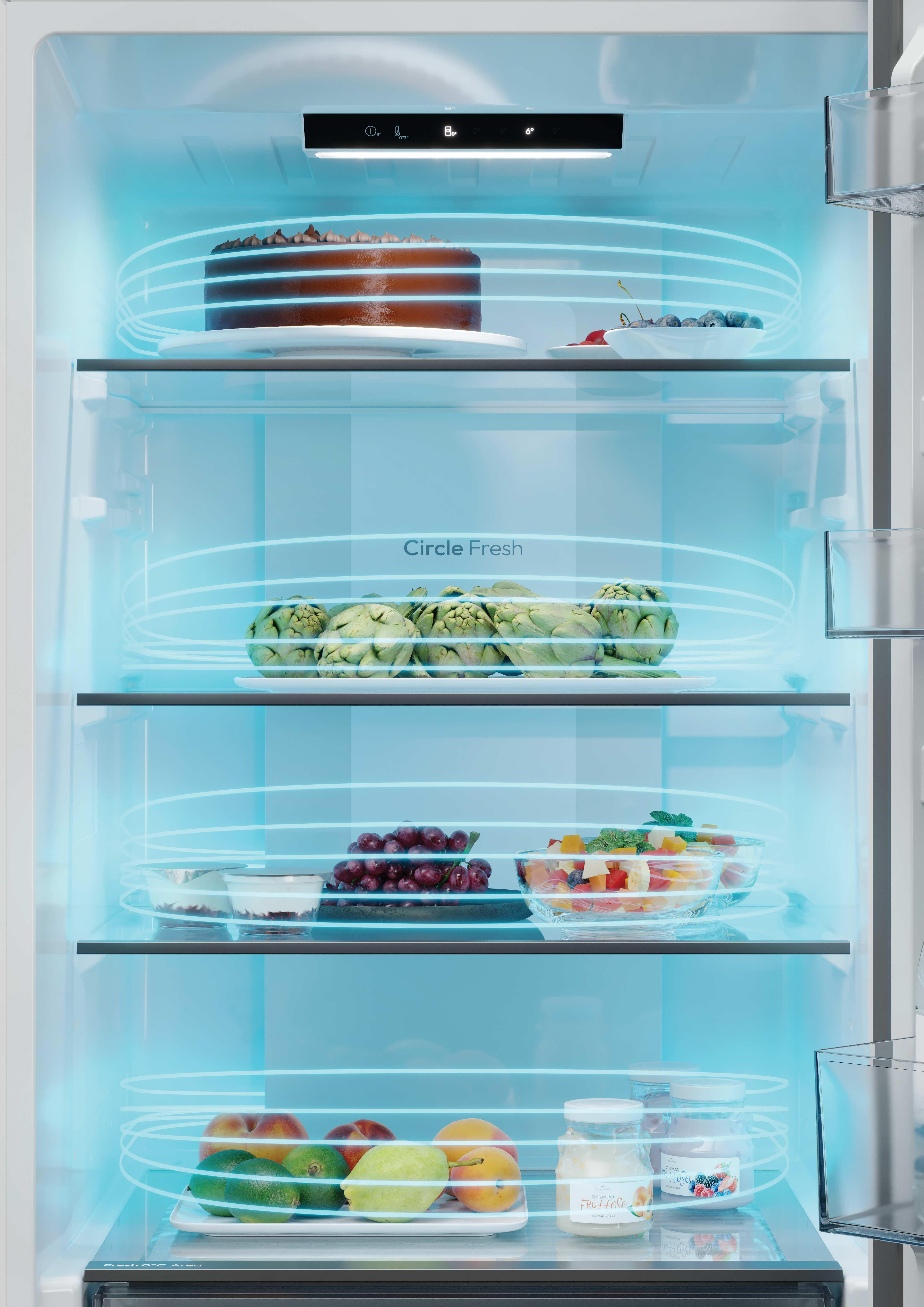 Refrigerador abierto con alimentos en los estantes. Pastel, frutas y verduras son visibles. La luz azul rodea los artículos.