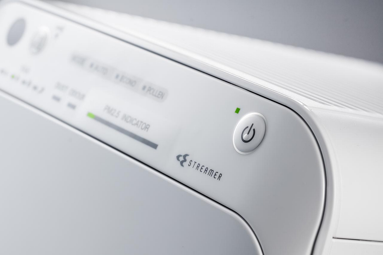 Panneau de commande du purificateur d'air blanc, montrant le bouton d'alimentation, l'indicateur PM2.5 et le logo Streamer.