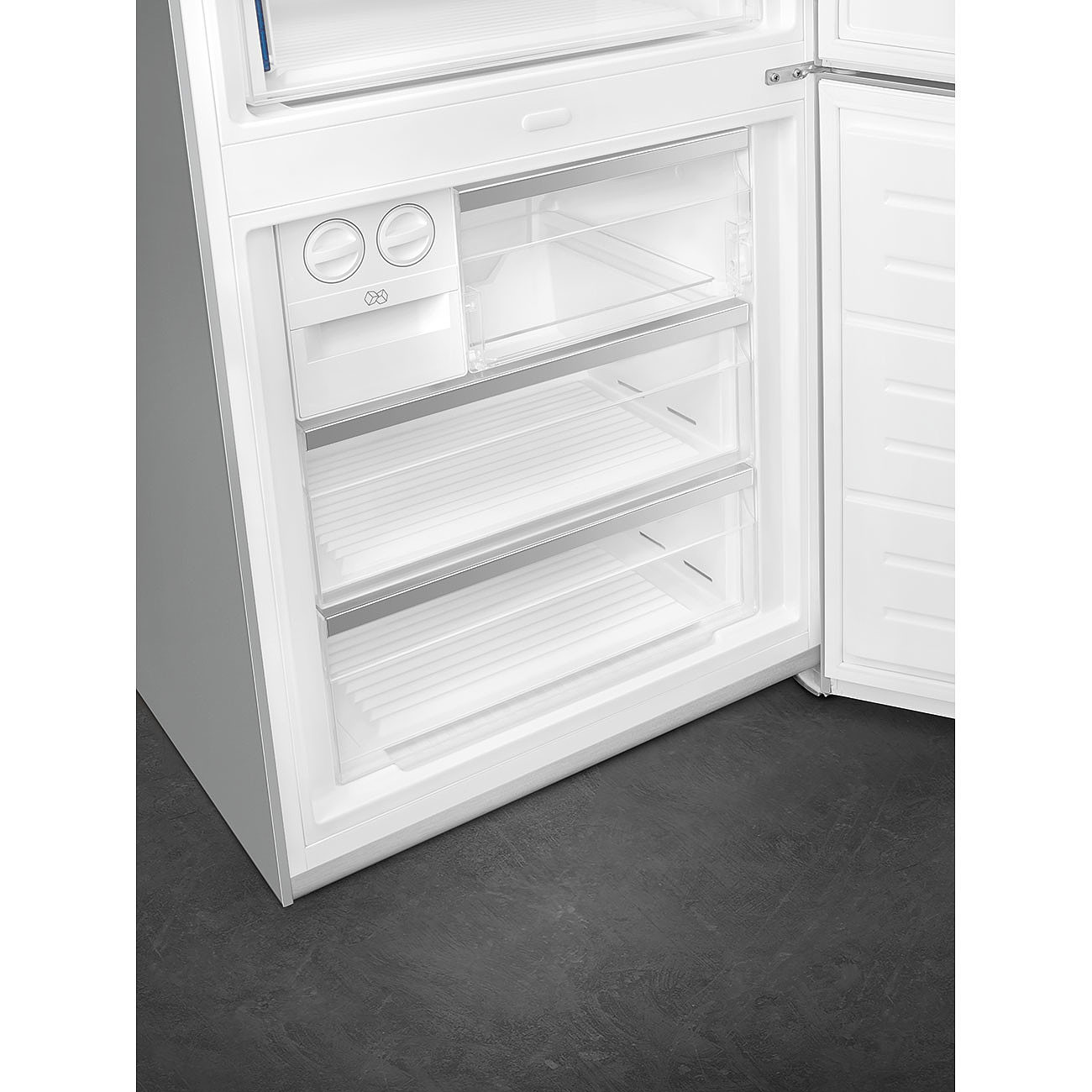 Interior de un refrigerador. Estantes y cajones transparentes. Blanco y negro.