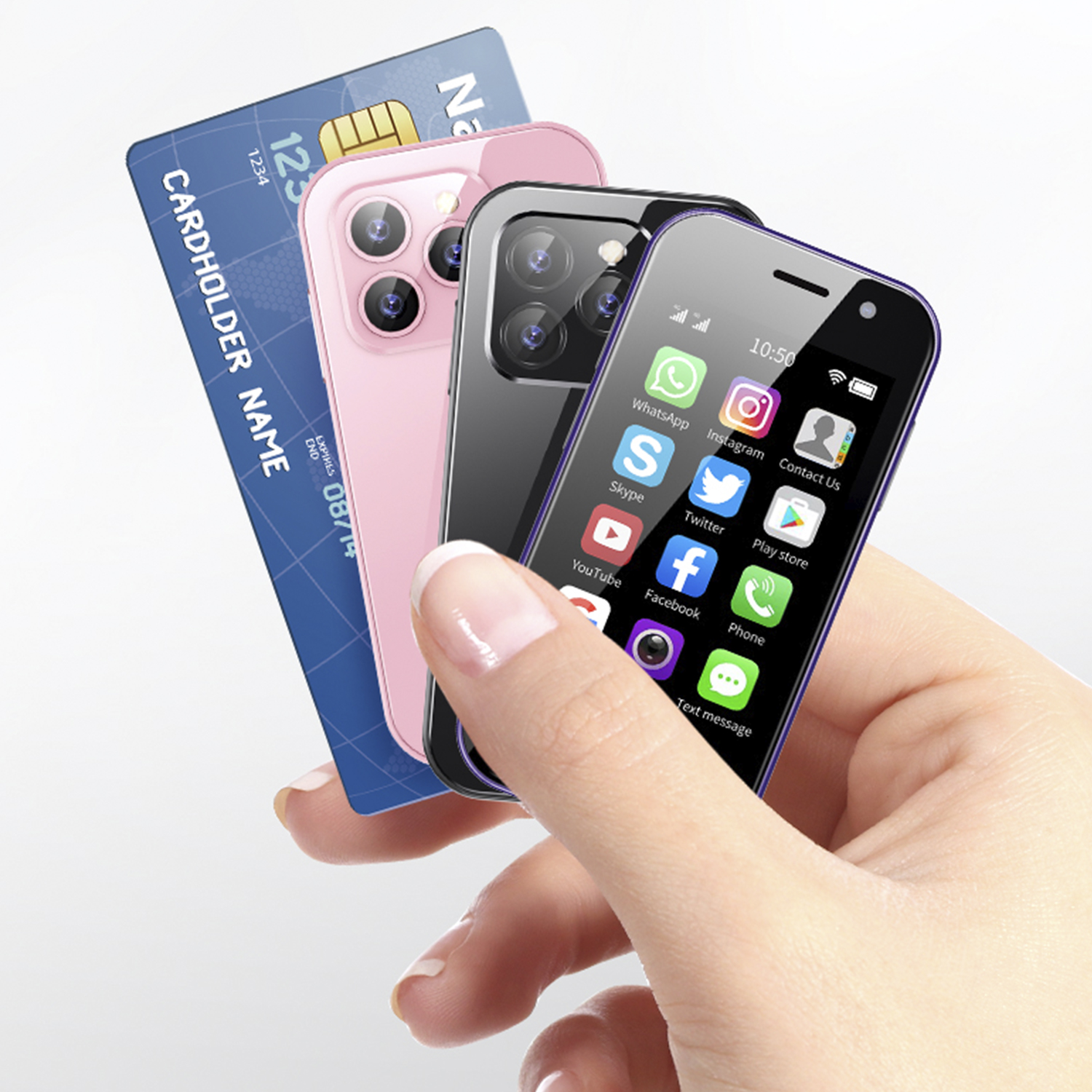 Una mano che tiene tre piccoli telefoni accanto a una carta di credito; telefoni rosa, neri e viola.