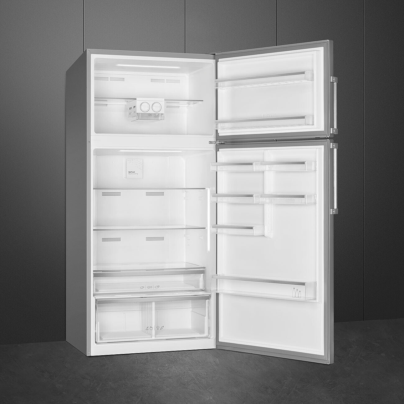 Frigorifero aperto in acciaio inossidabile. Interno con ripiani, cassetti e scomparti, parzialmente illuminato.