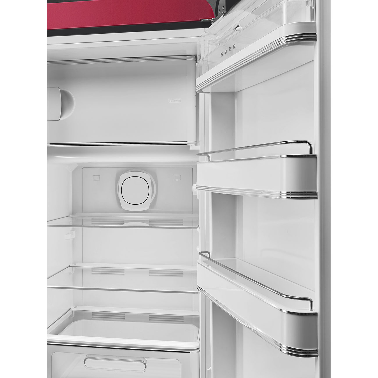 L'interno aperto di un frigorifero SMEG rosso con ripiani, cassetti e luce.