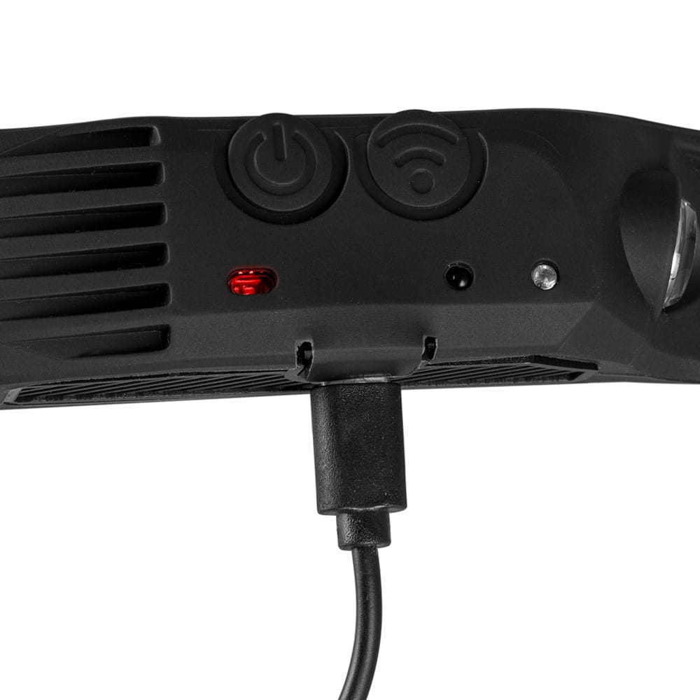 Tył czarnej latarki czołowej z portem ładowania, przyciskami i czerwonym światłem.