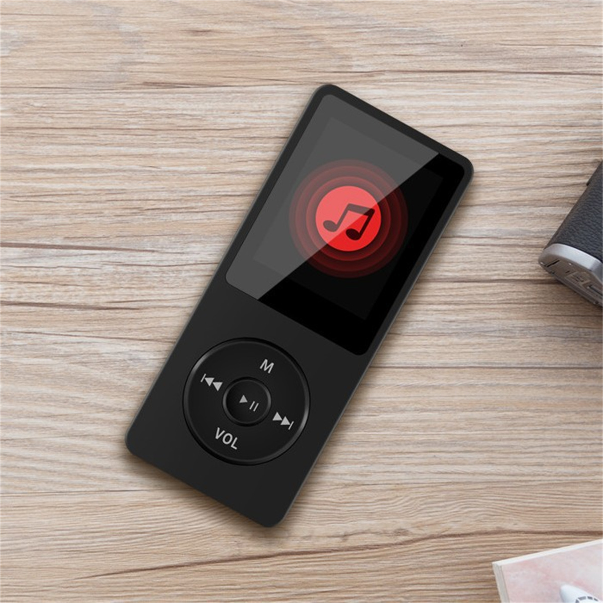 Ein schwarzer MP3-Player mit rotem Notensymbol auf dem Bildschirm, der auf Holz liegt.