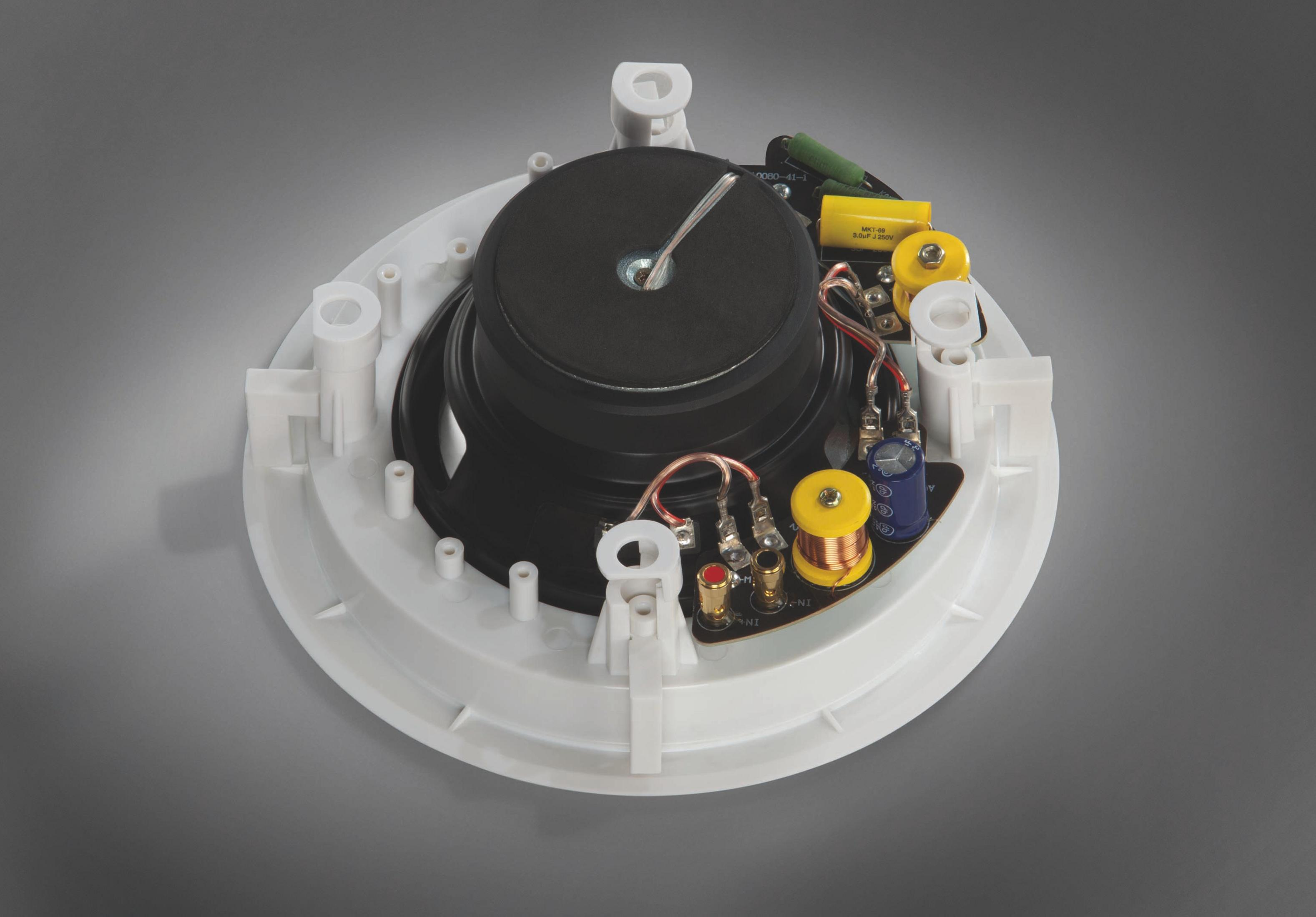 Altoparlante rotondo bianco con centro nero, cablaggio e componenti visibili.