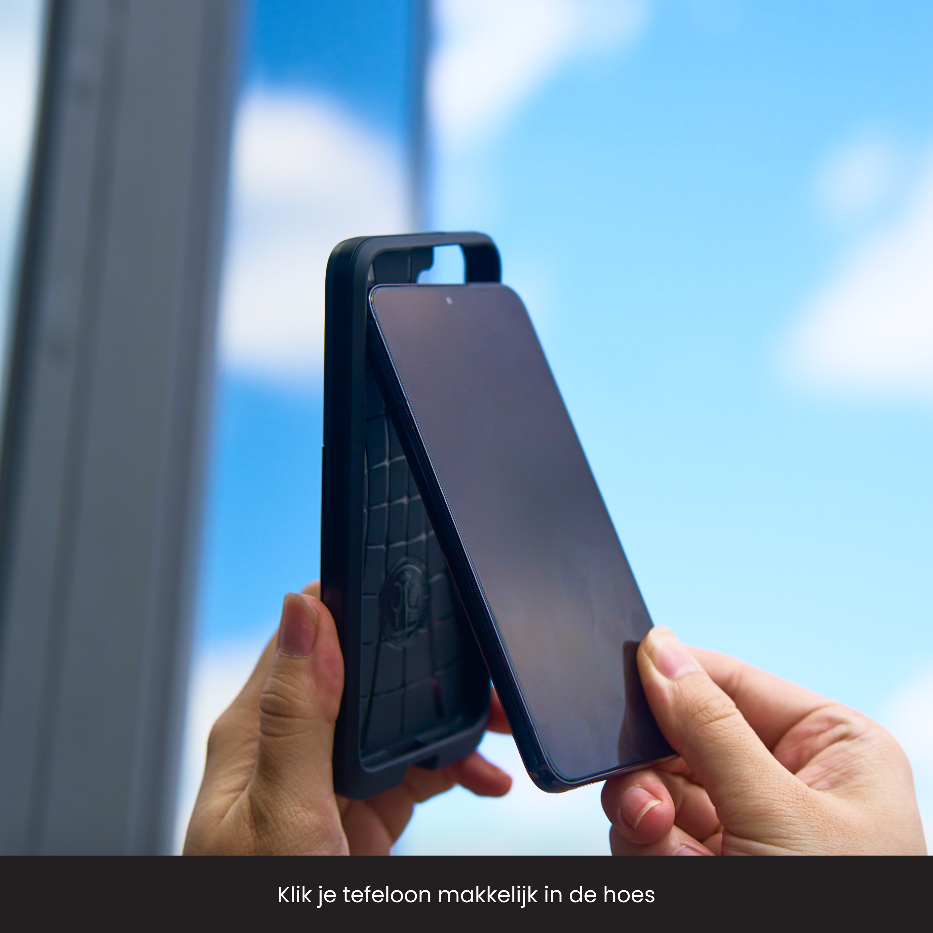 Une main place un protecteur d'écran sur un téléphone à l'intérieur d'une coque noire.