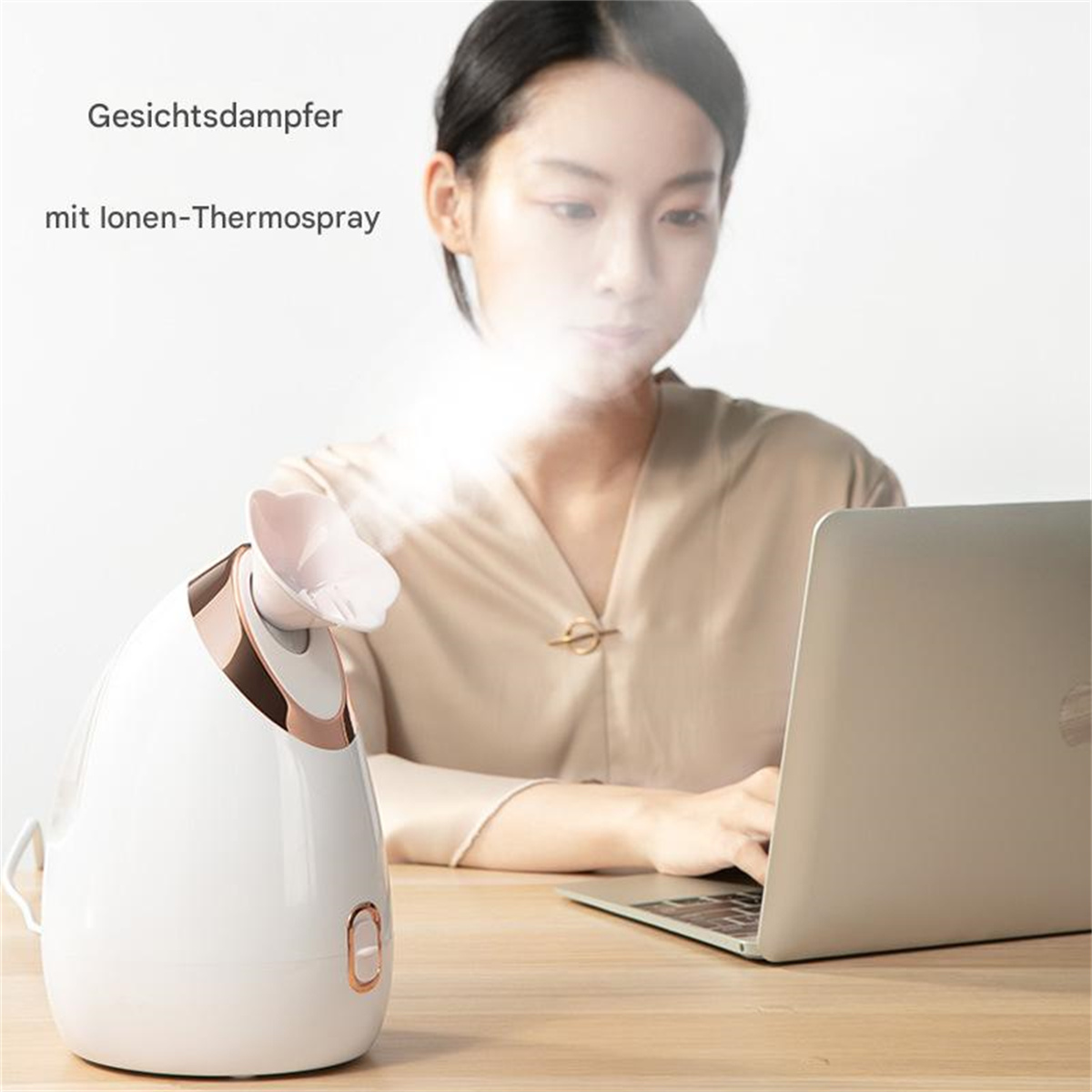 Eine Frau benutzt einen Laptop, während ein Gesichtsdampfer Dampf abgibt.