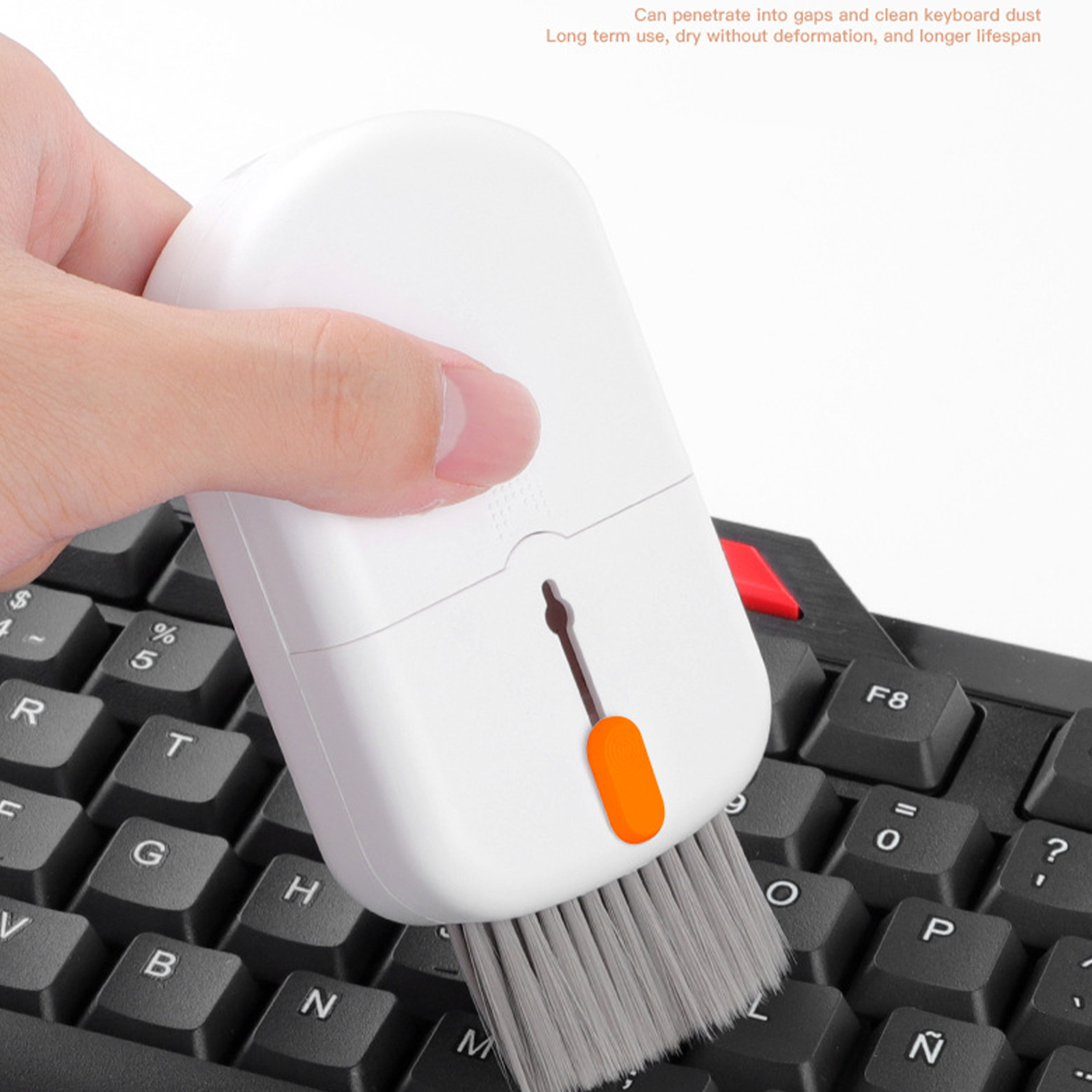 Hand reinigt Tastatur mit Bürste und Reinigungswerkzeug.