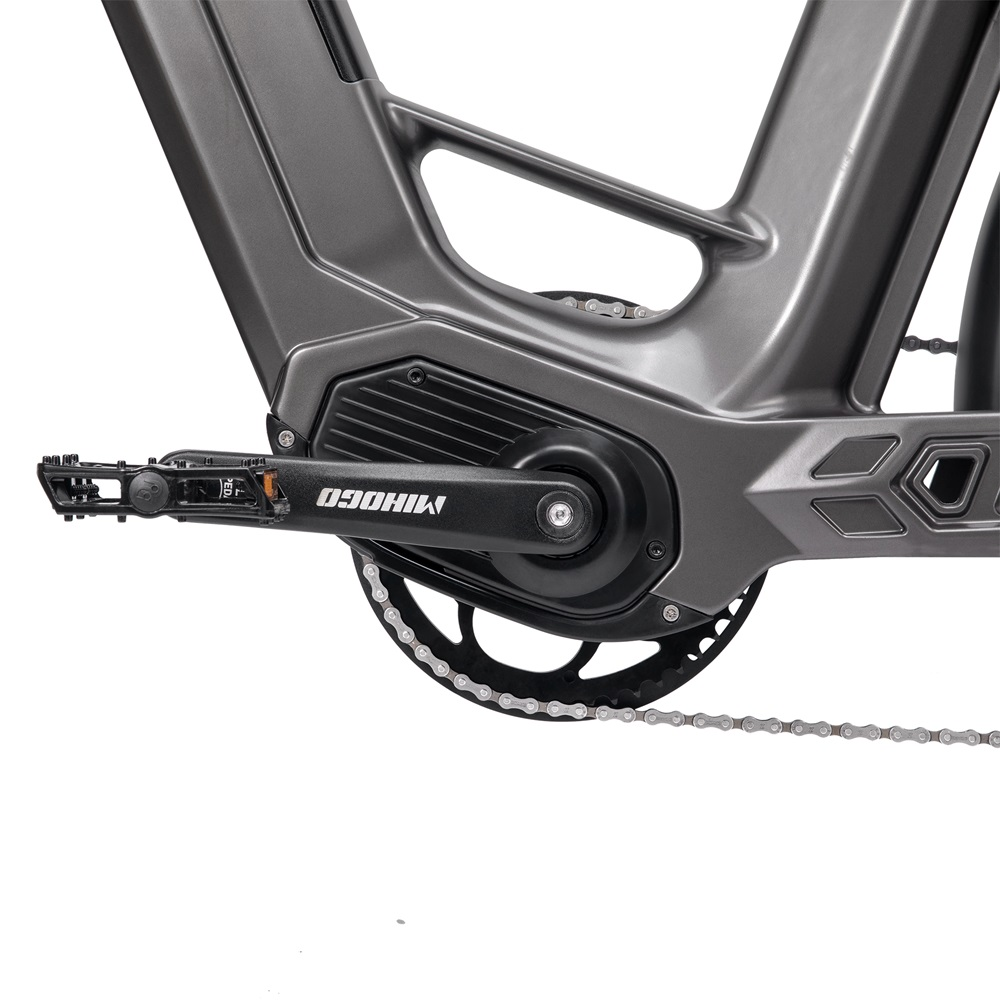 Primo piano sulla catena e sui pedali di una bici elettrica. Colore grigio.