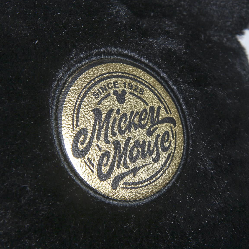 Mochila negra con un emblema dorado de Mickey Mouse. El emblema dice 'Mickey Mouse' y 'Since 1928'.