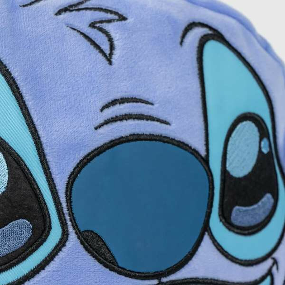 Nahaufnahme eines blauen Stitch-Plüschtiergesichts mit großen Augen und einem verspielten Ausdruck.