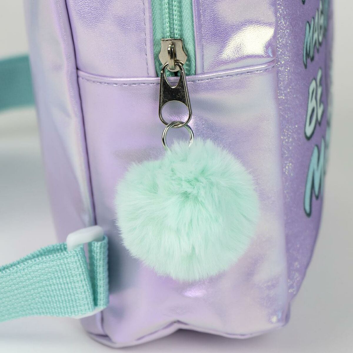 Nahaufnahme eines lilafarbenen Rucksacks mit einem mintgrünen Bommel am Reißverschluss.