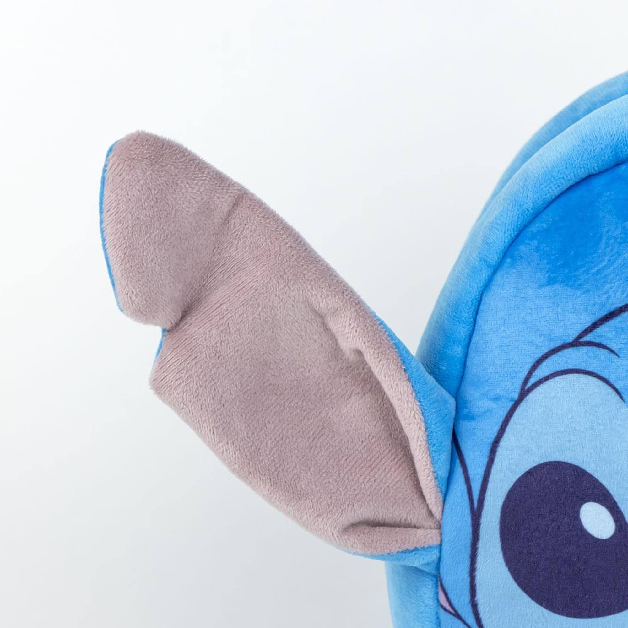 Primer plano de la oreja de Stitch en una mochila azul. El fondo es blanco.