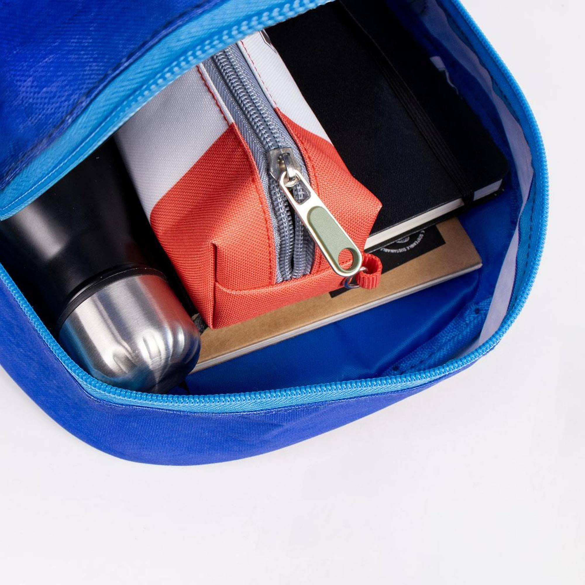 Interior de la mochila de Sonic the Hedgehog. Contiene una botella de agua, estuche, cuaderno y un libro.